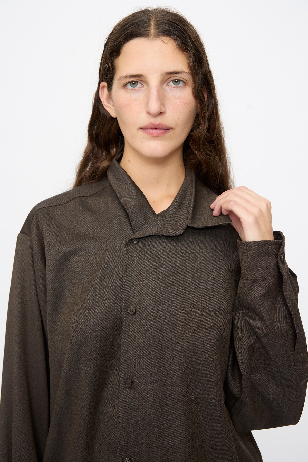 A person wearing a brown melange Wool No. 82 Neckerchiefdress featuring an oversized, collared silhouette with an asymmetrical scarf neckline.