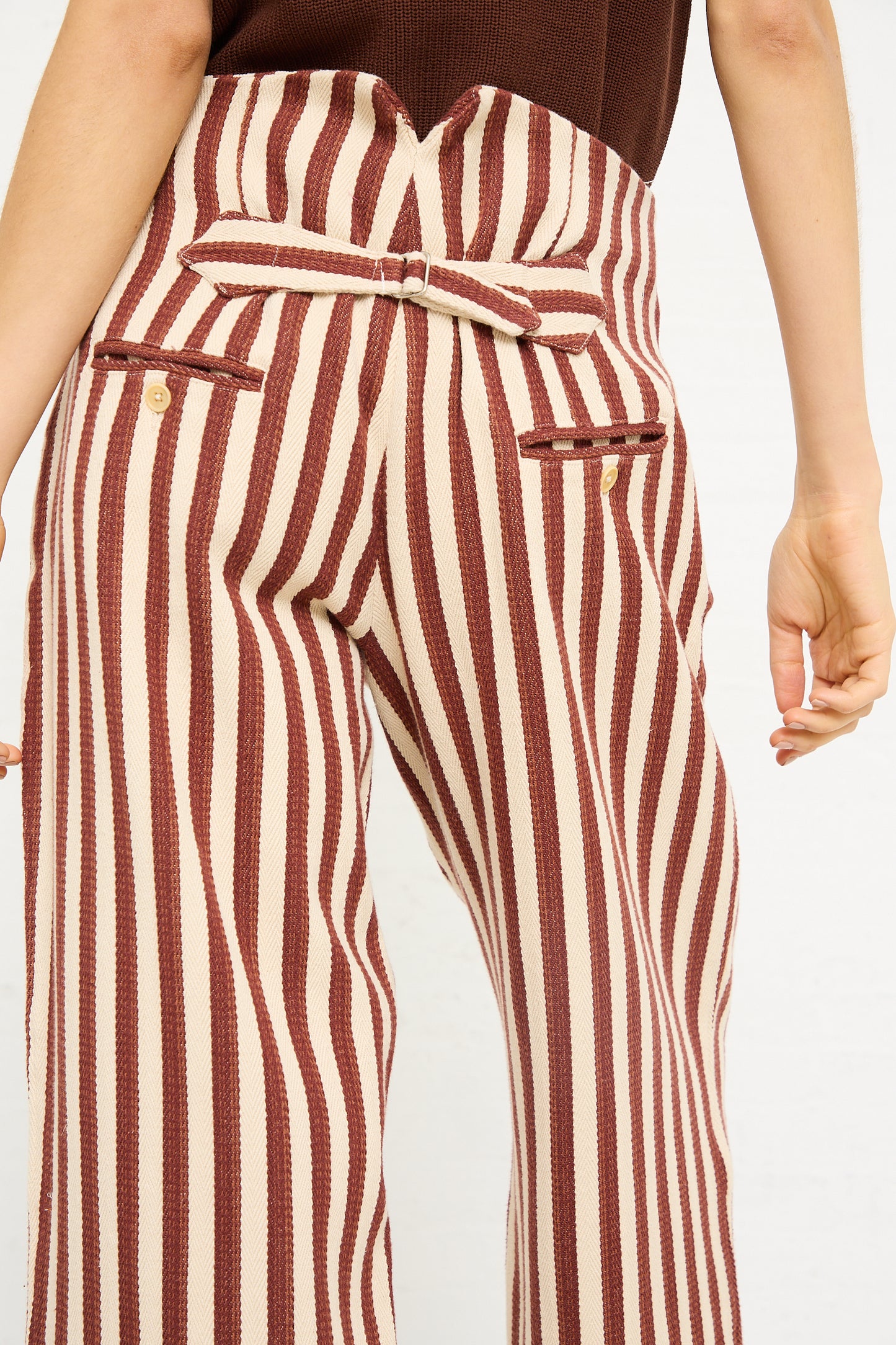 Close-up of a person wearing Caron Callahan's Dexter Pant in Auburn Stripe with a brown belt, emphasizing the high waist and side pockets.