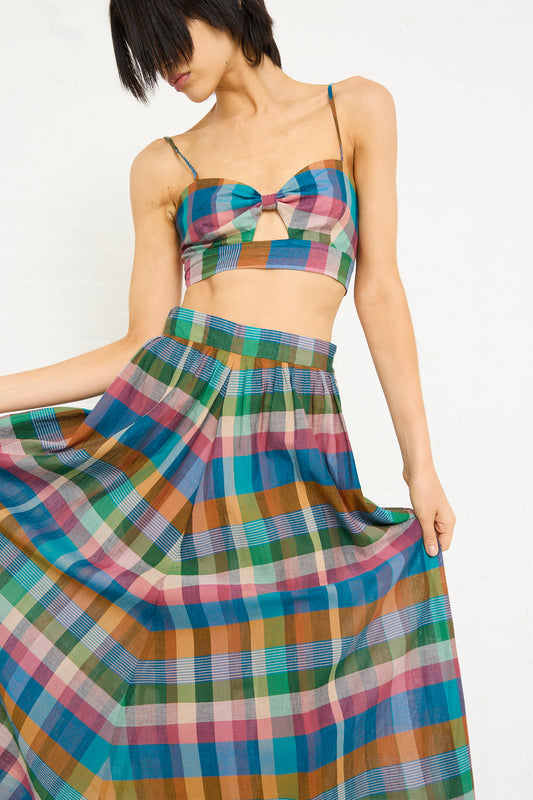Woman in a Caron Callahan Carla Bralette in Bright Space Dyed Plaid dress with a bow on the top, standing against a white background.