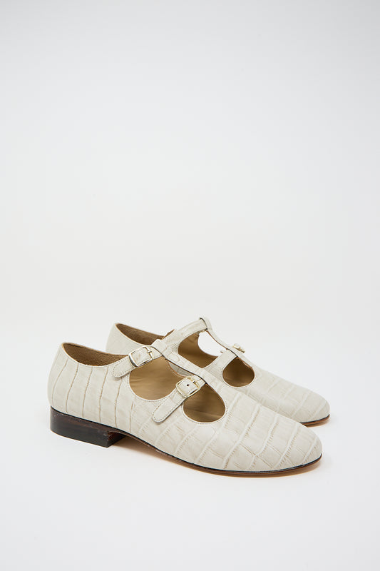 A pair of Caron Callahan Alfie Flat in Ivory Embossed Leather monk strap shoes against a plain background.