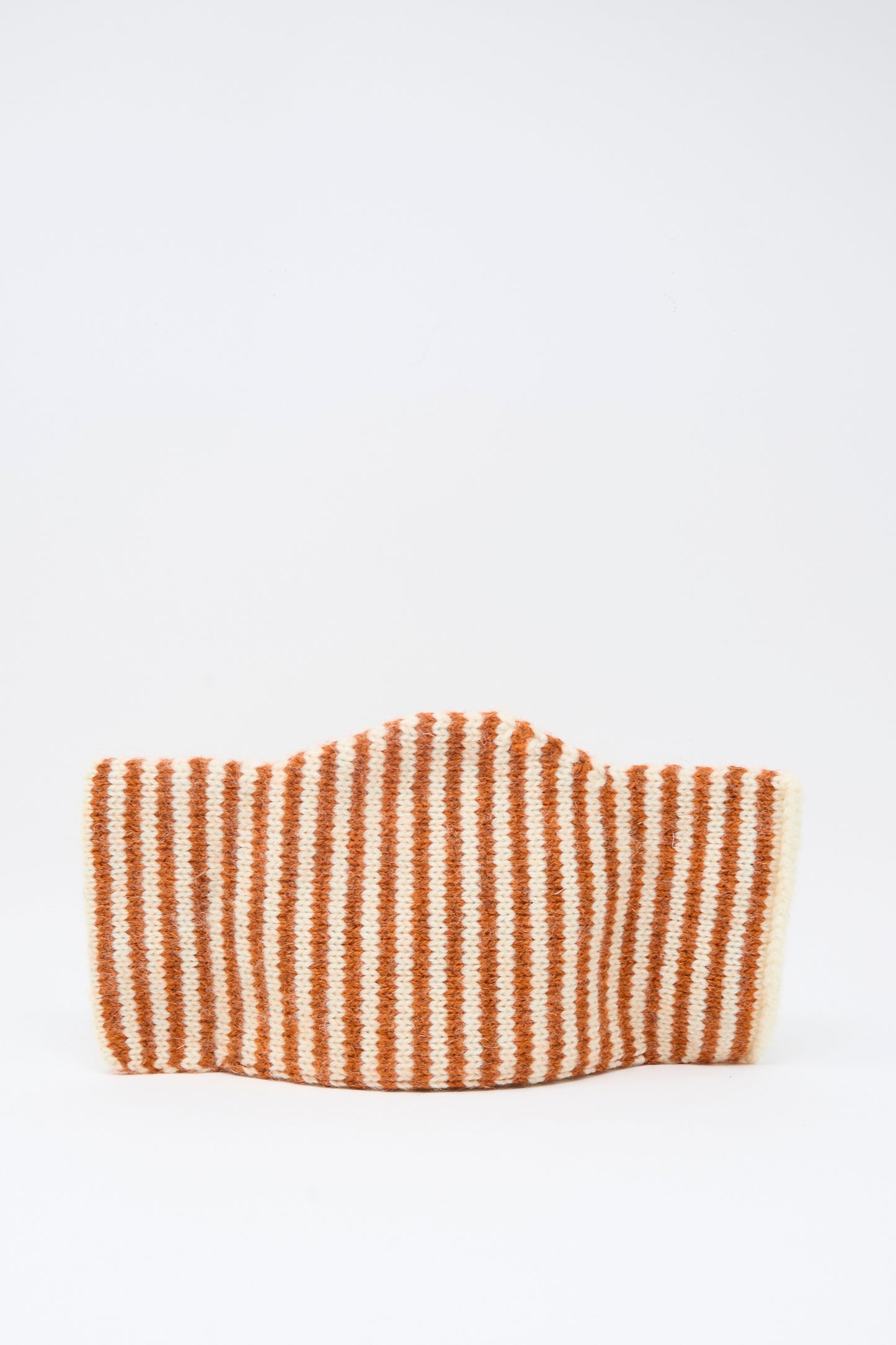 The Brushed British Wool Stripe Bow Hat in Natural and Autumn by Cawley, featuring horizontal orange and white stripes, stands upright against a plain white background.
