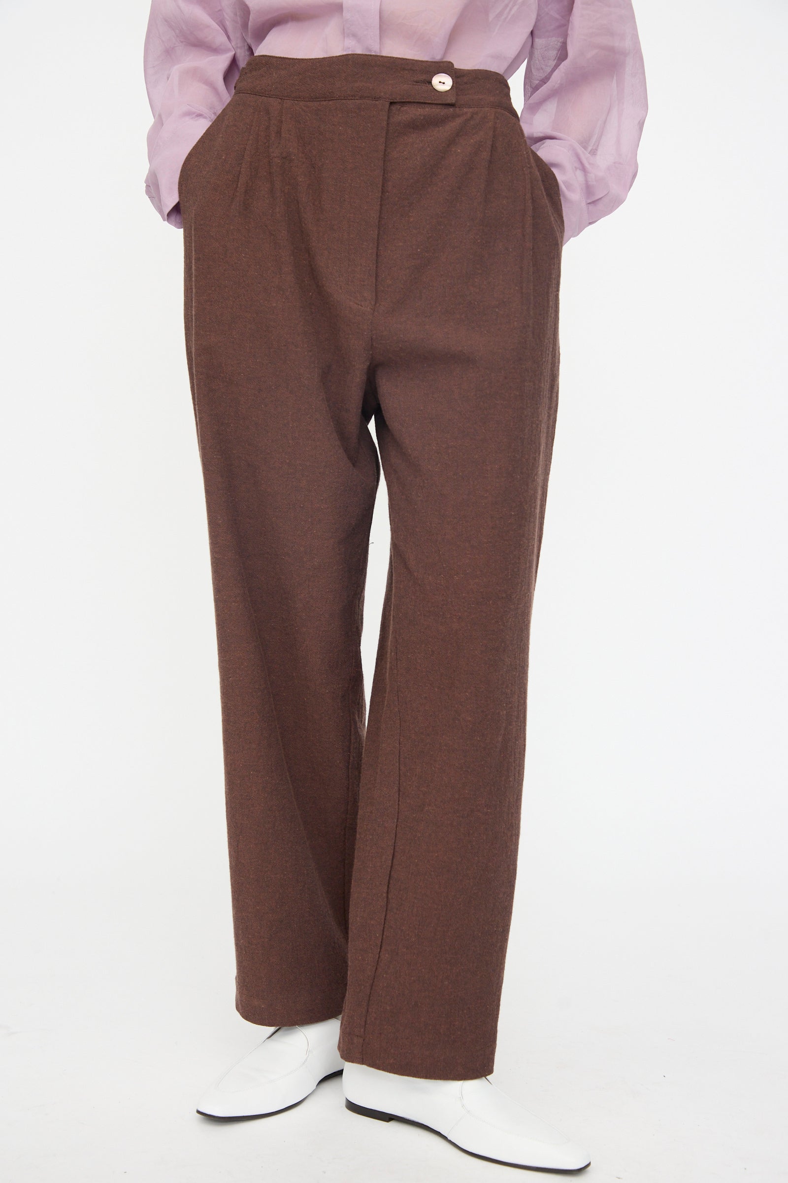 Person wearing Cawley’s Japanese High Twisted Poplin Enya Trouser in Fog Purple with an adjustable waistband, white shoes, and a light purple shirt, standing against a plain white background.
