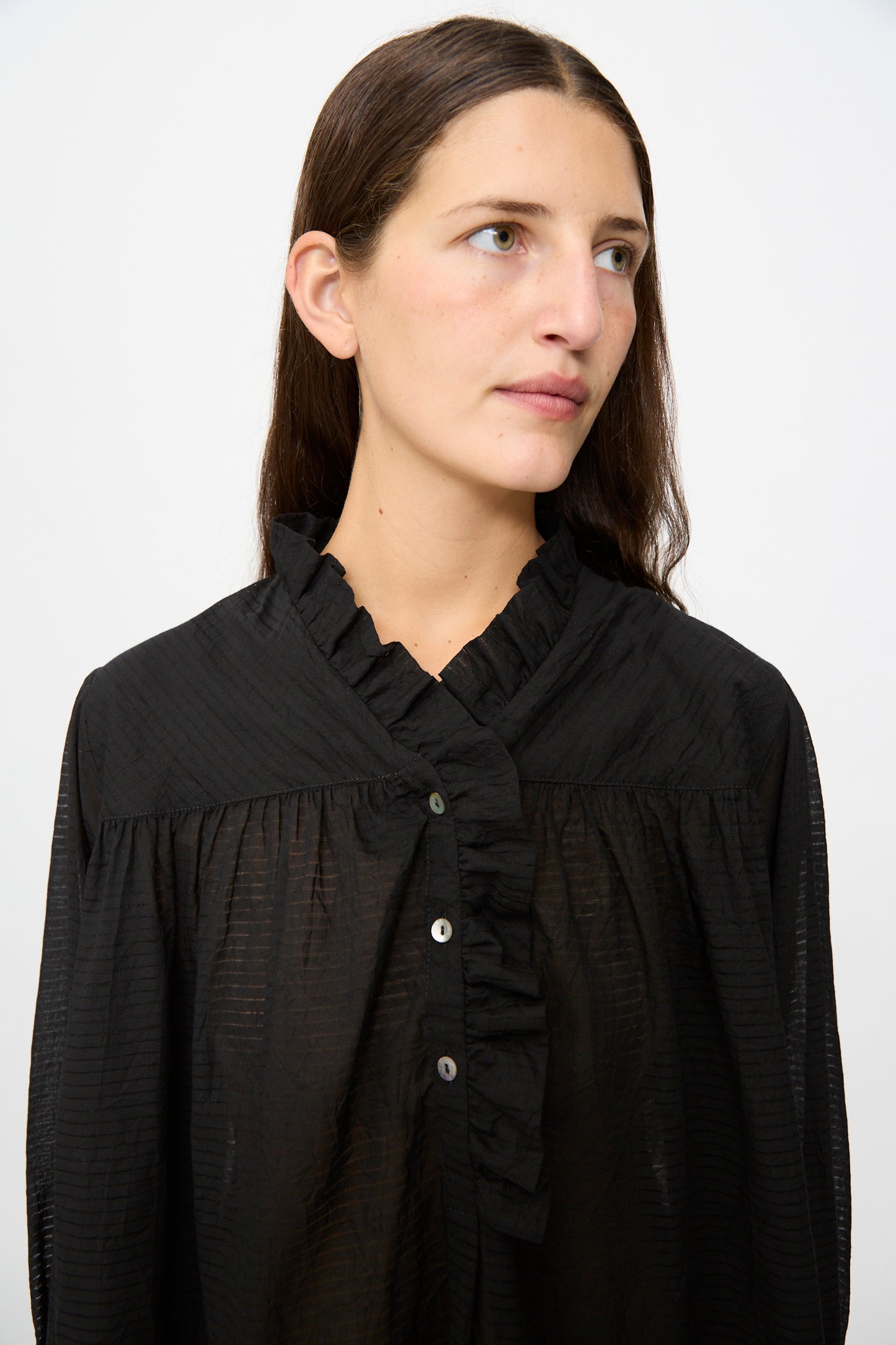 Woman with long brown hair wearing the Cawley Japanese Sheer Stripe Cotton Sophie Shirt in Midnight, looking to the side against a plain light background.