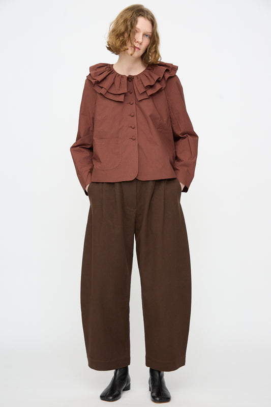 A person wearing the Japanese Typewriter Cotton Rowan Jacket in Burgundy Stripe by Cawley, standing against a plain white background.