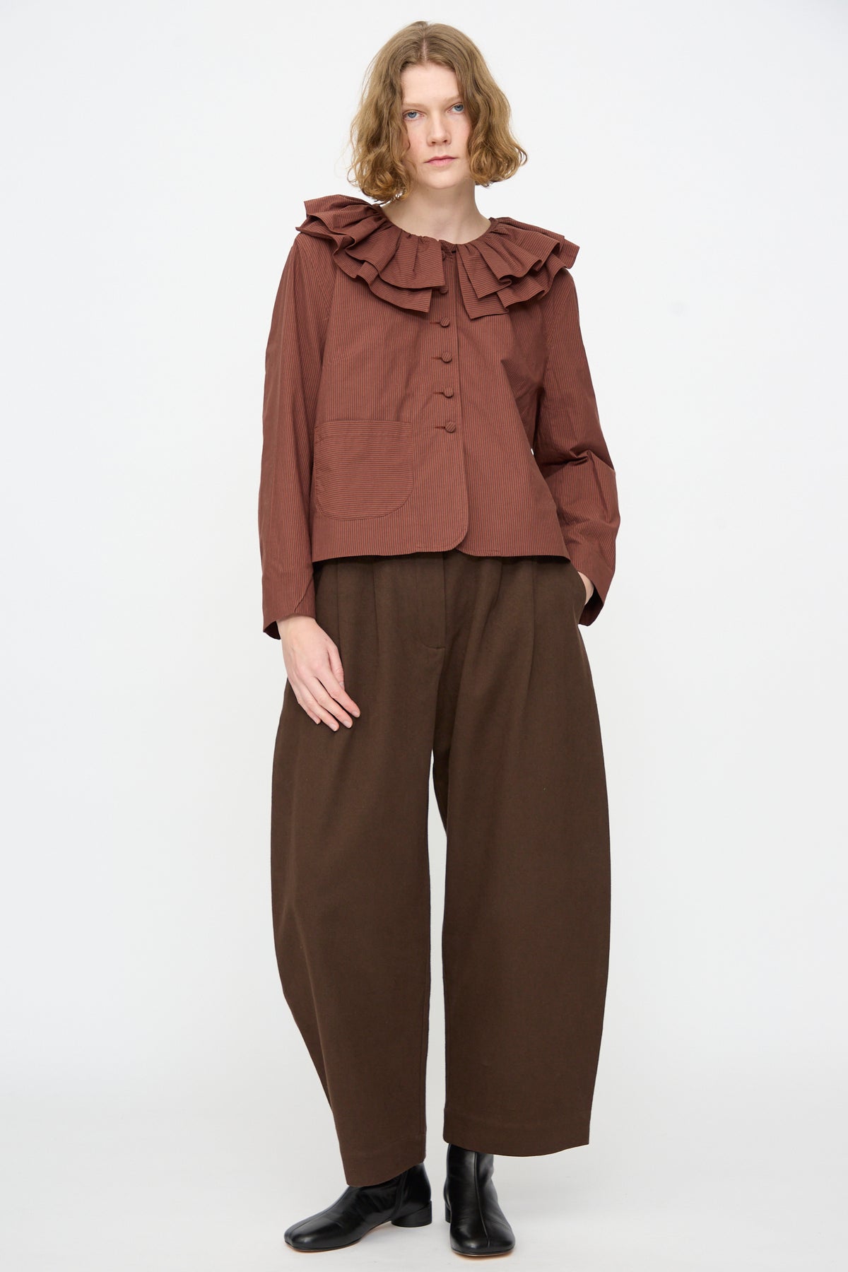 Person standing against a plain background wearing the Cawley Japanese Typewriter Cotton Rowan Jacket in Burgundy Stripe.