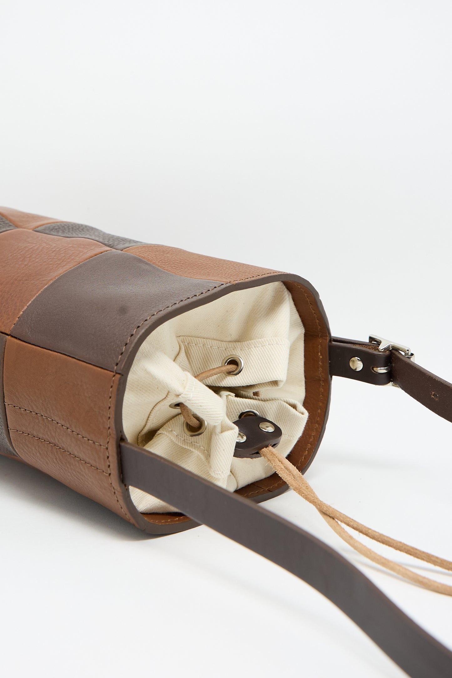 A close up of the Leather Bucket Bag in Chocolate and Tan by Cawley, made from Italian leather, with a brown and tan design and convenient straps.