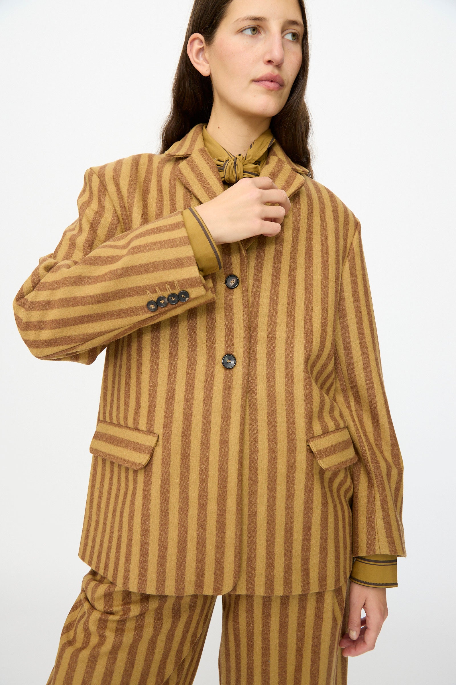Model wearing the Cawley Portuguese Striped Wool Andie Blazer in Goldfinch and Bordeaux, paired with a matching shirt, standing against a plain white background.