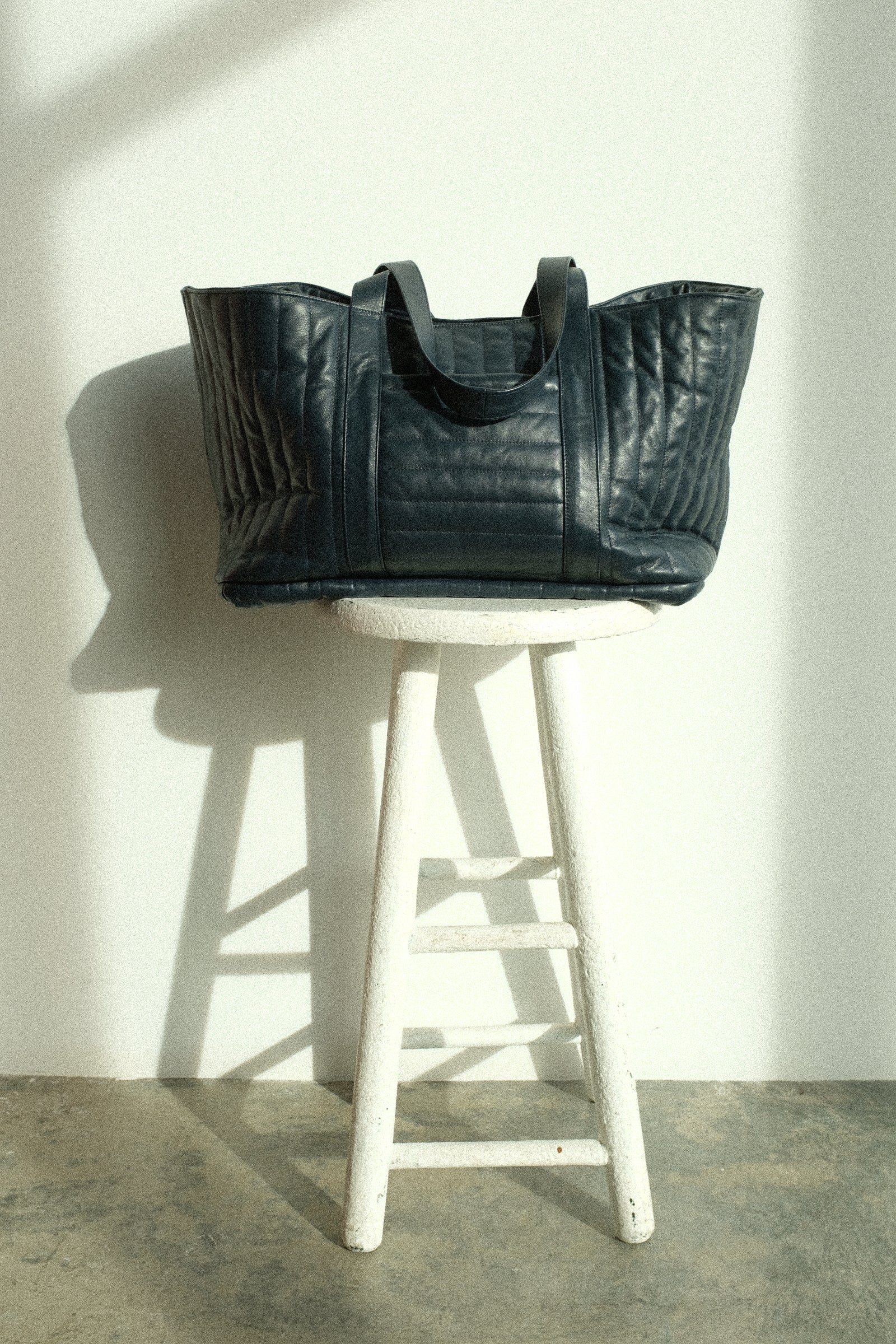 Cawley's Quilted Nappa Large Tote Bag on a stool against a white background.