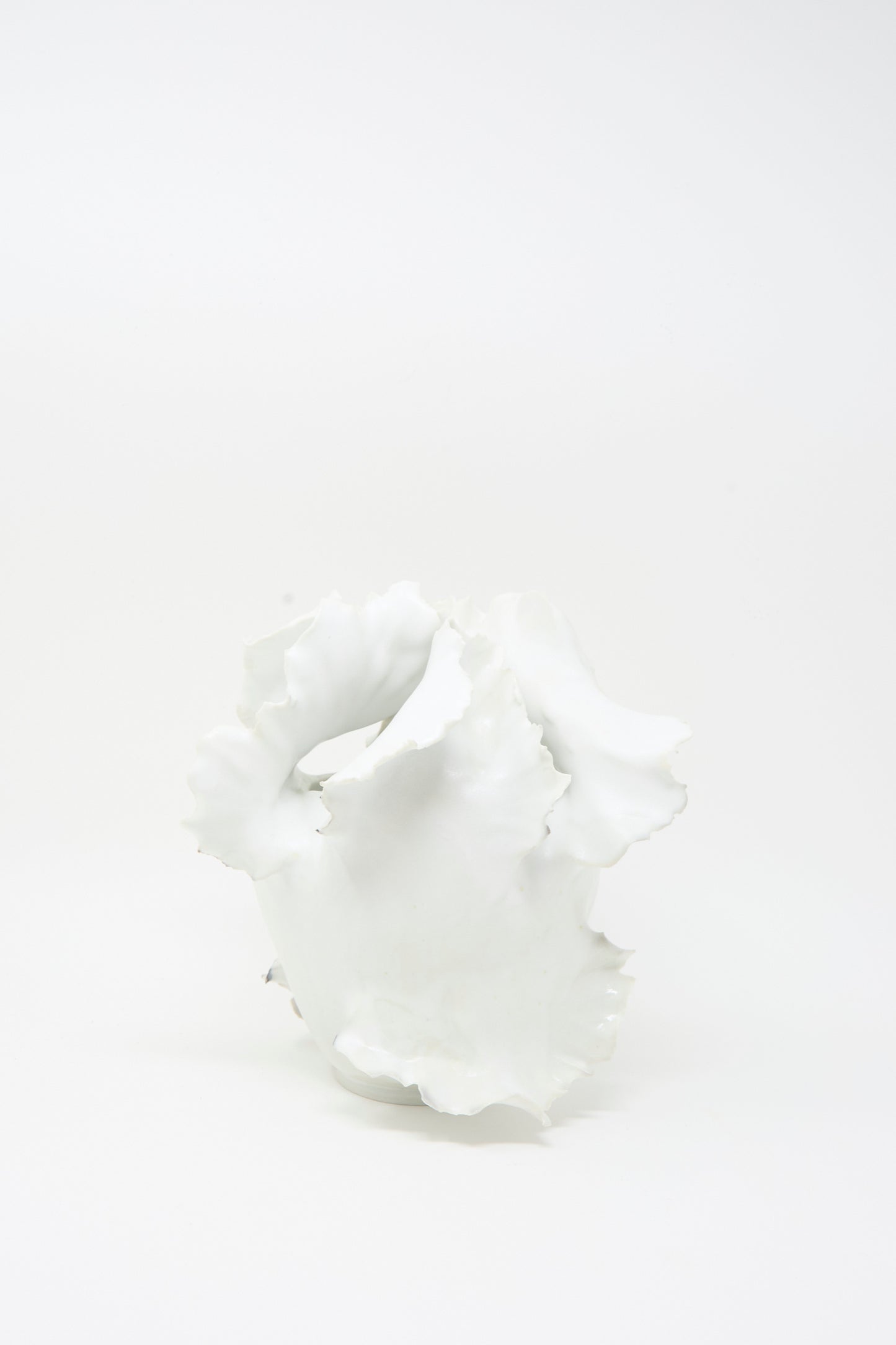 Roots N3 Sculpture in White by Chala Toprak—a white abstract ceramic piece with wavy, irregular edges reminiscent of a handmade vase crafted from sculpture clay—displayed on a plain white background.
