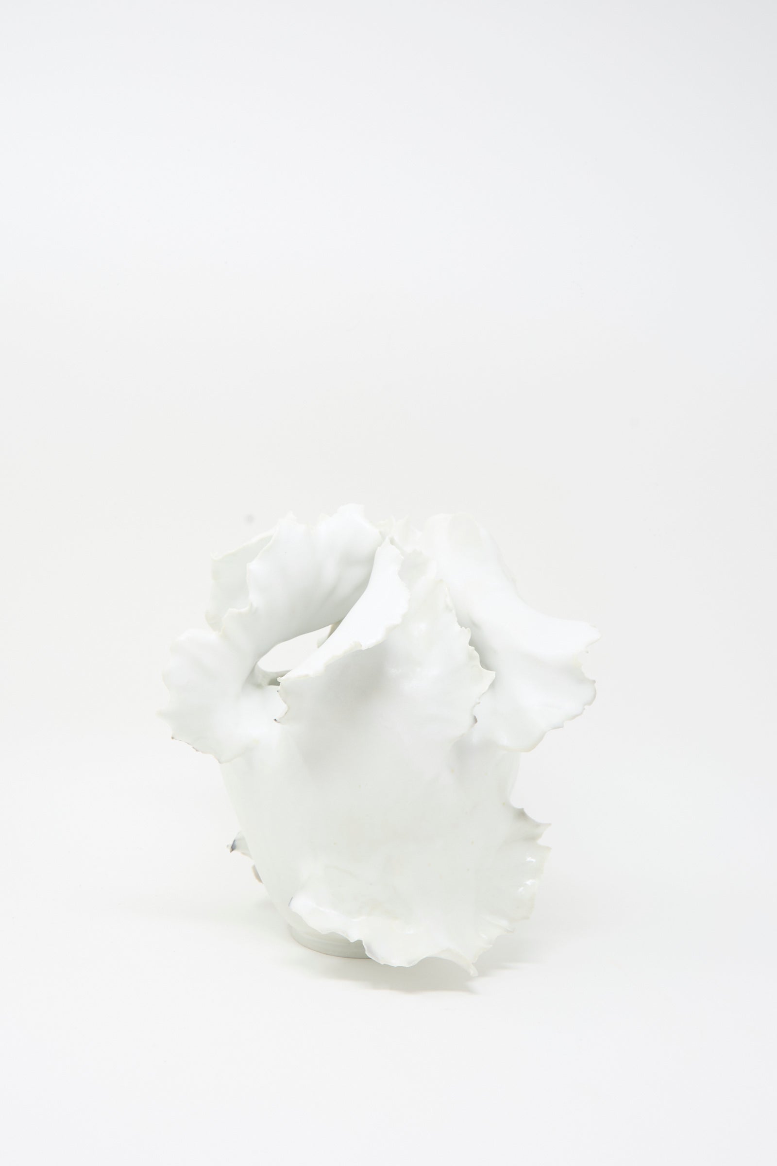Roots N3 Sculpture in White by Chala Toprak—a white abstract ceramic piece with wavy, irregular edges reminiscent of a handmade vase crafted from sculpture clay—displayed on a plain white background.