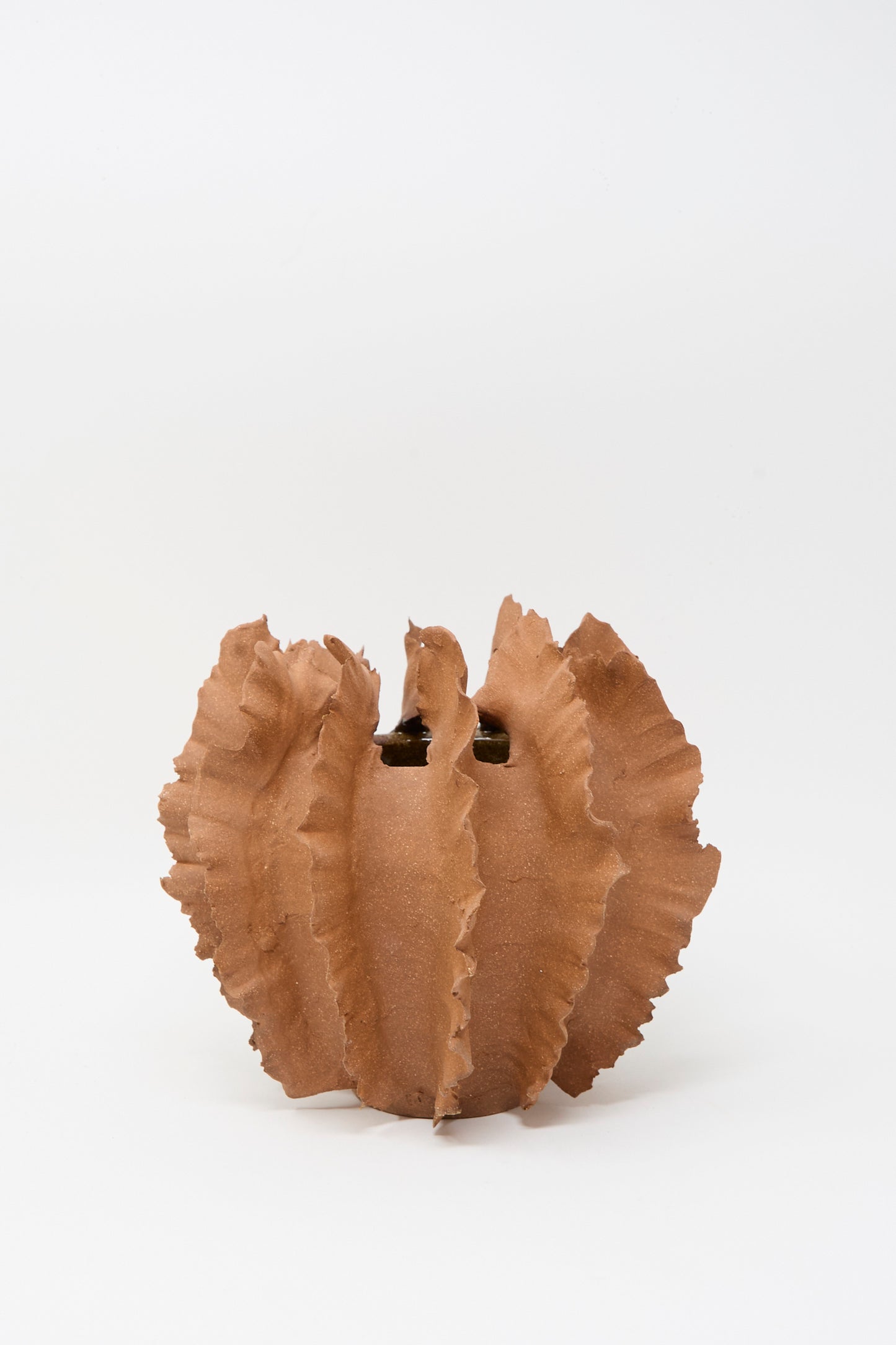 The Wild Petal Mini Vase in Terracotta by Chala Toprak is a sculptural, handmade stoneware piece with ruffled, wavy edges, displayed against a plain white background.