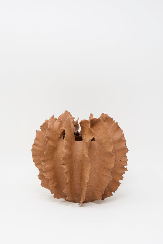 The Wild Petal Mini Vase in Terracotta by Chala Toprak, featuring a round stoneware form with jagged, ruffled edges, is displayed against a plain white background.
