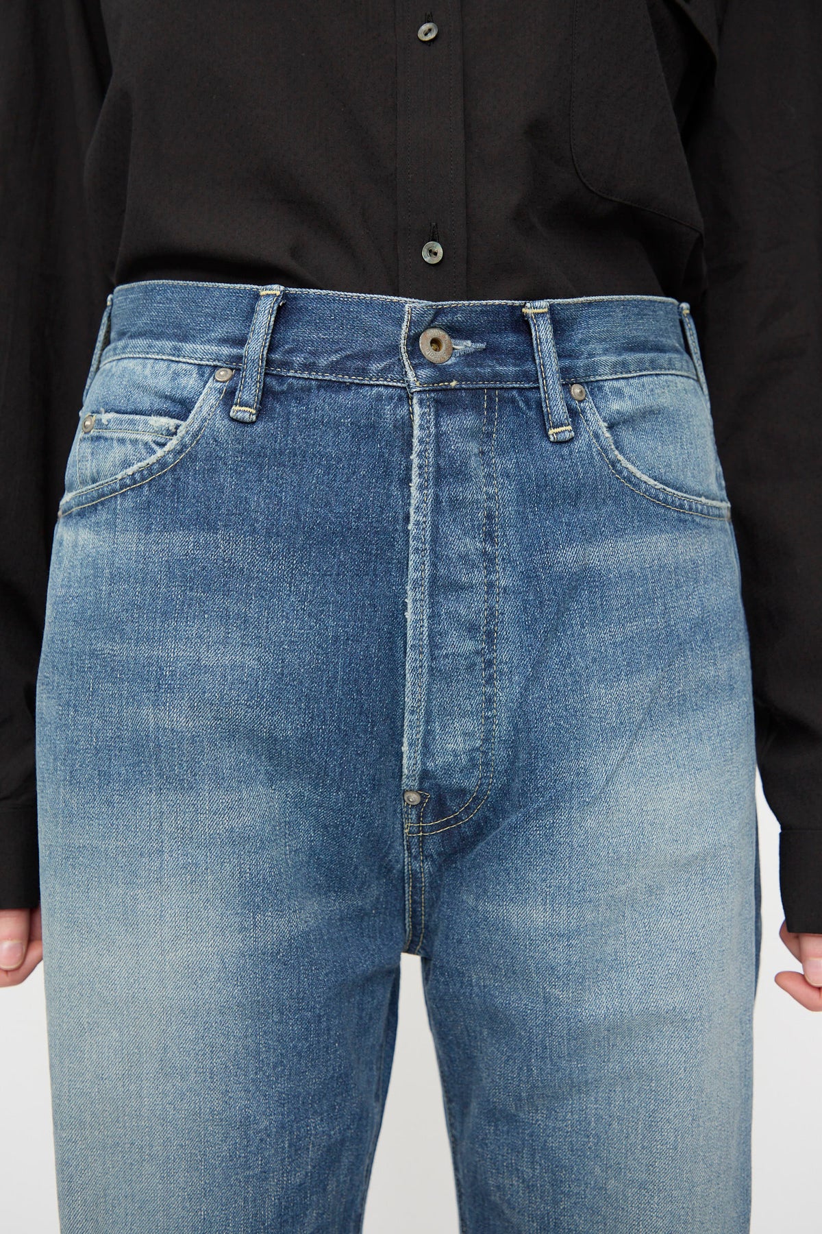A person is wearing a black button-up shirt tucked into Chimala 12oz Denim Straight Cut in Work Light Blue jeans, featuring a high-waisted fit and faded wash.