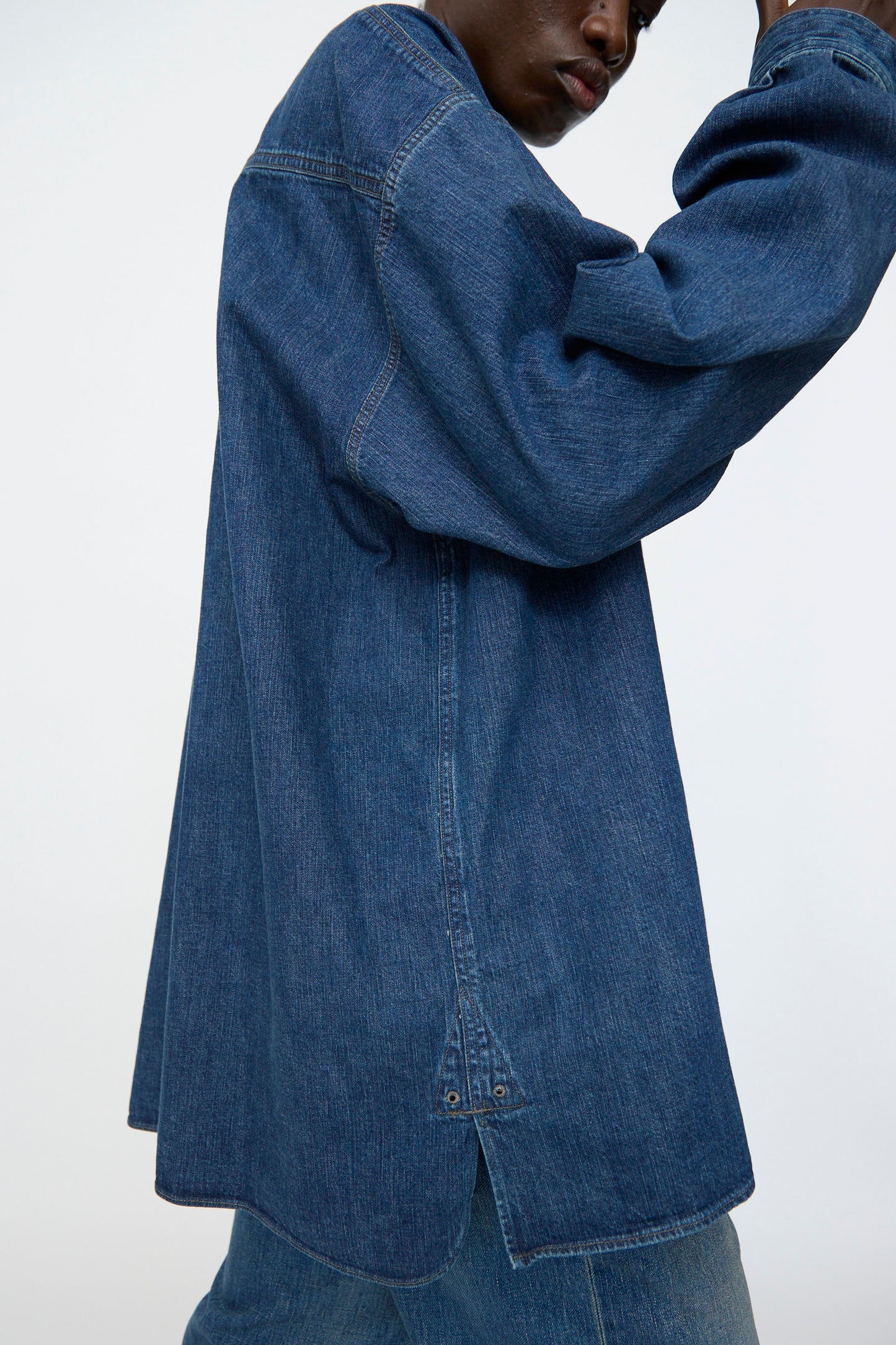 A person is shown from the side wearing Chimala’s 8oz. Denim US Navydeck Shirt in Indigo, styled with matching denim pants and photographed against a plain background.