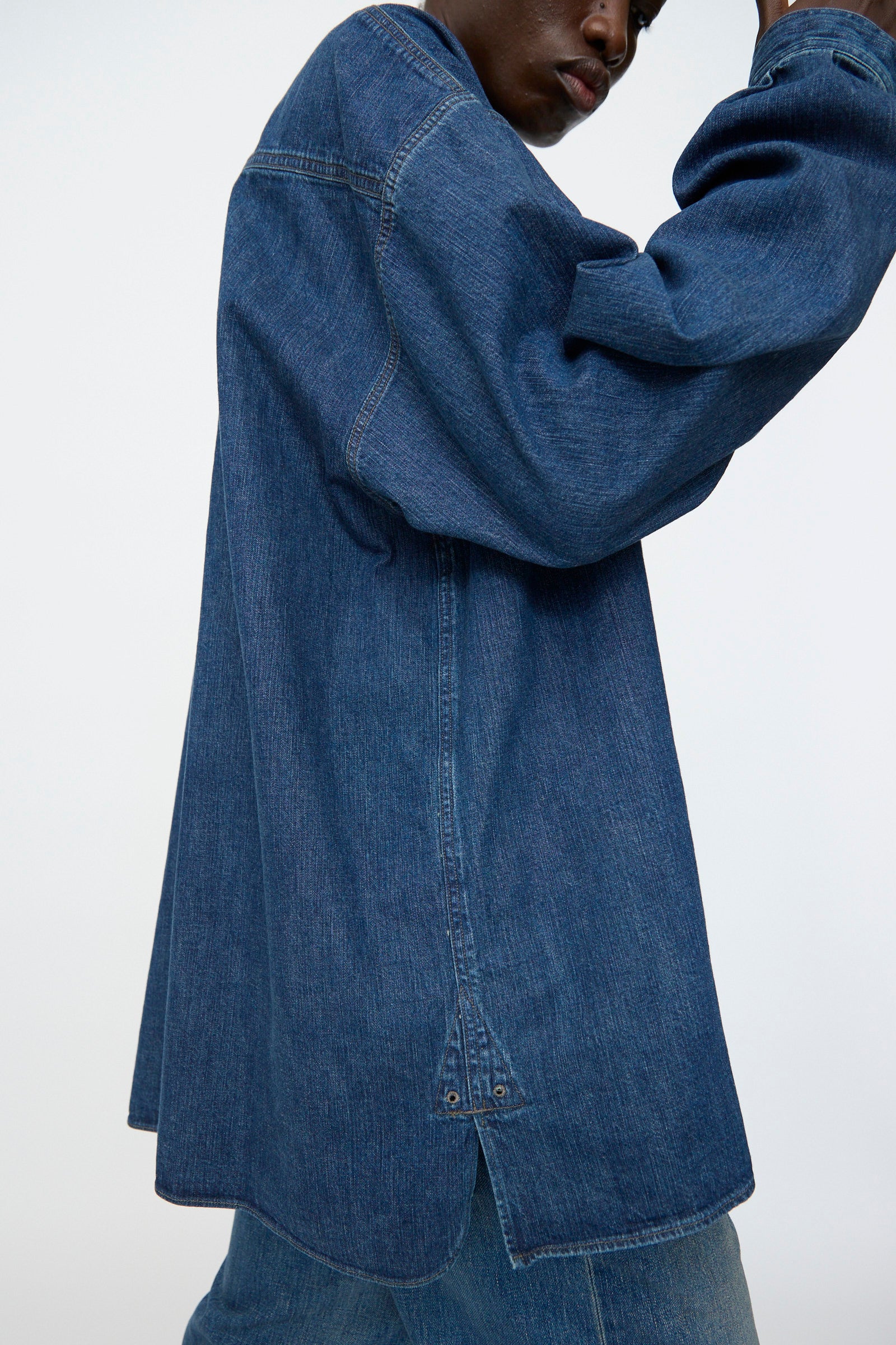 A person is shown from the side wearing Chimala’s 8oz. Denim US Navydeck Shirt in Indigo, styled with matching denim pants and photographed against a plain background.