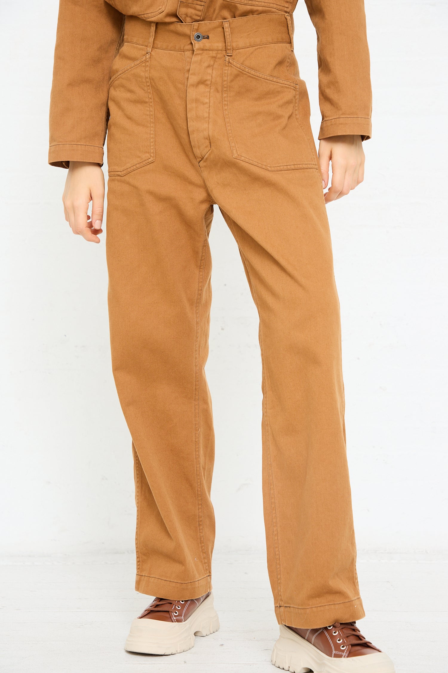 A person wearing Chimala Classic Drill US Army Work Trouser in Camel and two-tone sneakers.