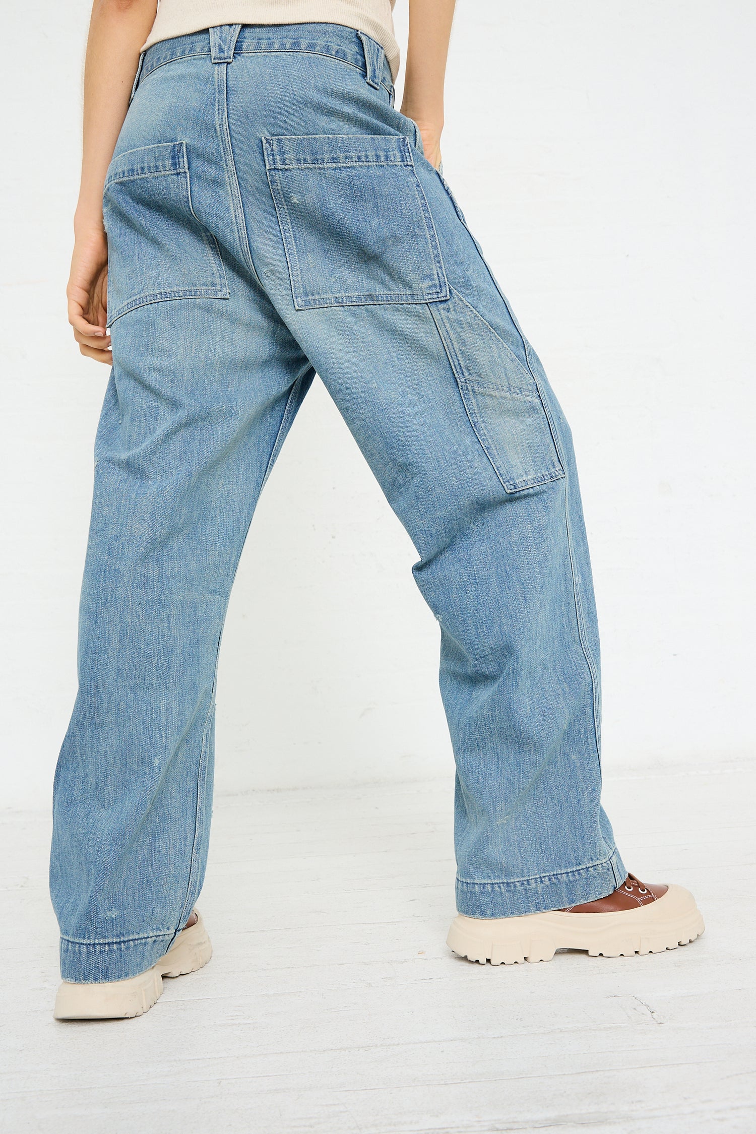 Person wearing Chimala Denim Painter Pant in Vintage Wash and beige shoes.