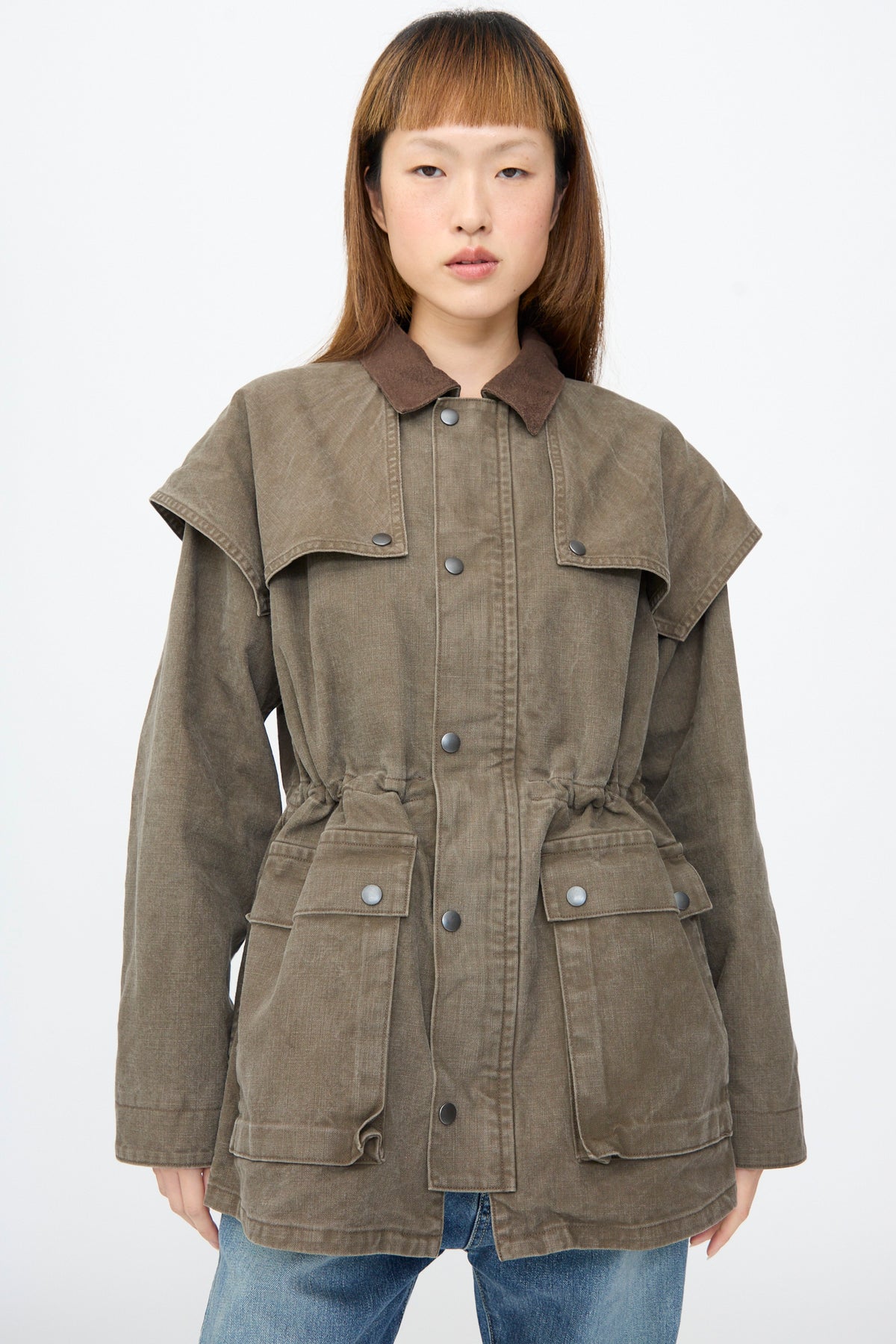 Chimala Sulfer Dyed Canvas Lumber Coat in brown, featuring an oversized fit, suede  collar, snap closures, and a tiered shoulder overlay.