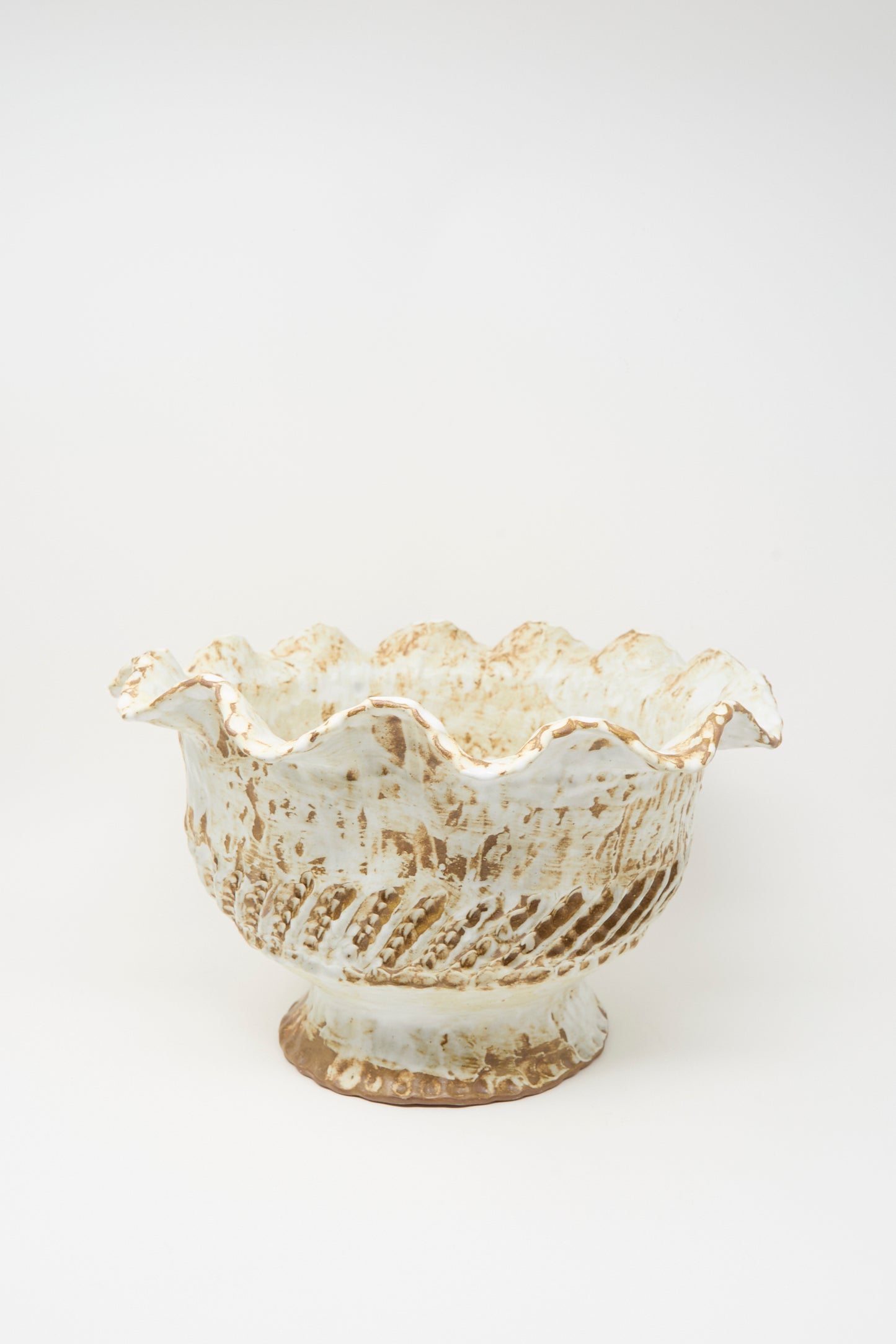 The Large Ridge Wave Bowl by Claire Resnick Ceramics is a hand-built ceramic piece featuring a scalloped rim, textured surface, and a blend of white and brown glaze. Made in the USA, it is photographed against a plain white background.