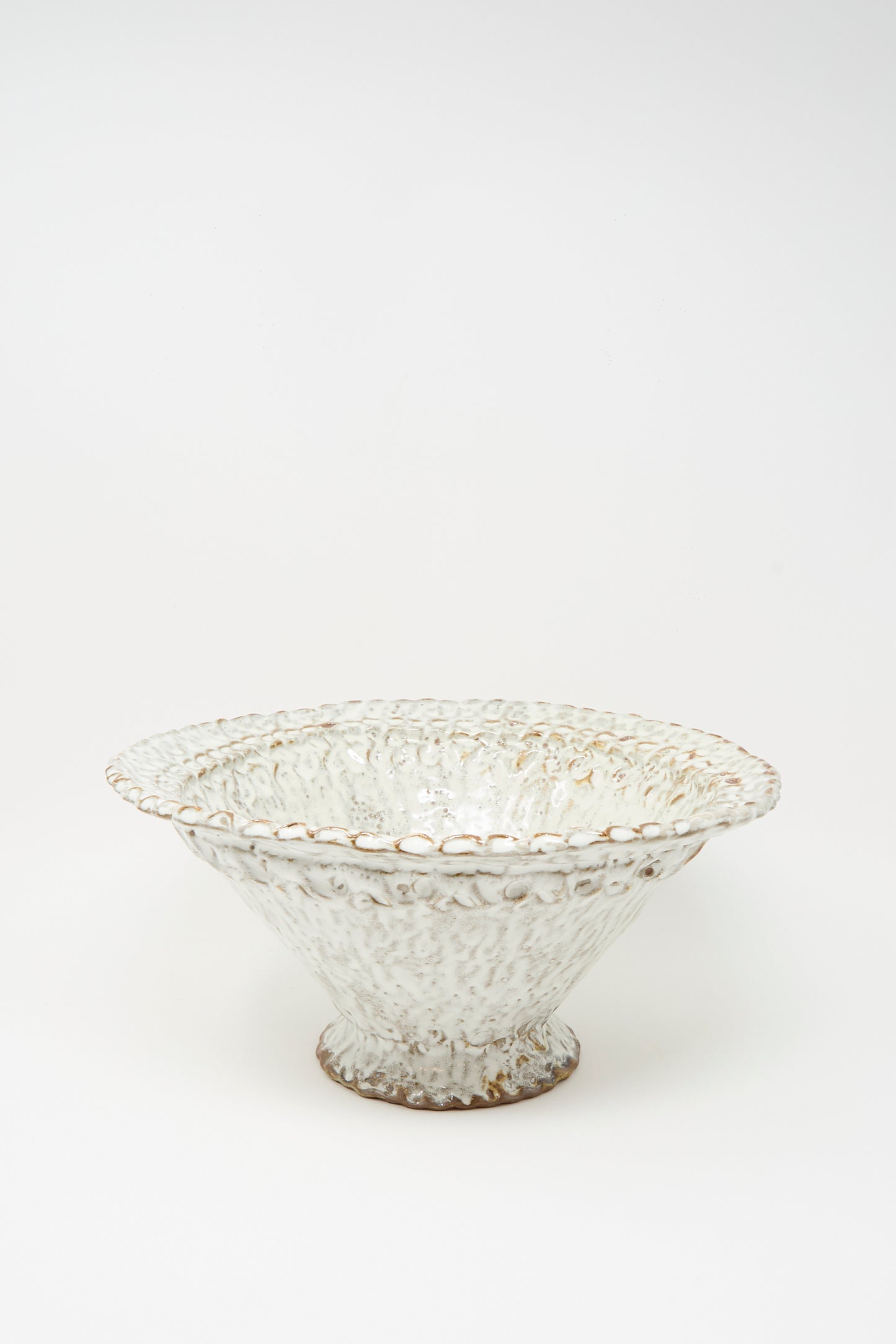 The Textured Bowl in White by Claire Resnick Ceramics features a wide, shallow shape with a scalloped, textured rim and a speckled white glaze, displayed against a plain white background.