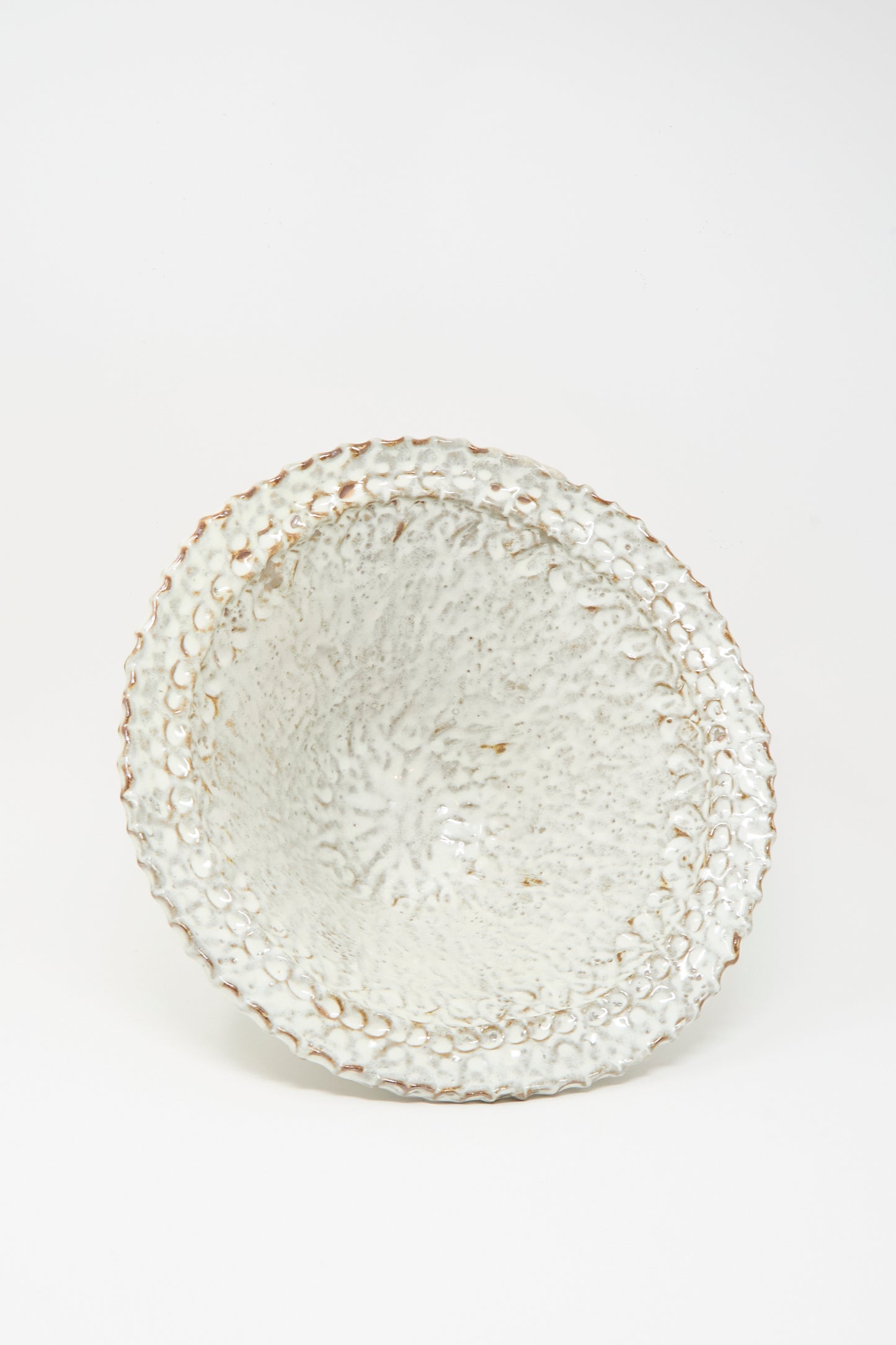 The Claire Resnick Ceramics Textured Bowl in White, featuring a handmade design with a white glaze and brown edges, is displayed against a plain white background; this large bowl brings artisanal charm to any table setting.