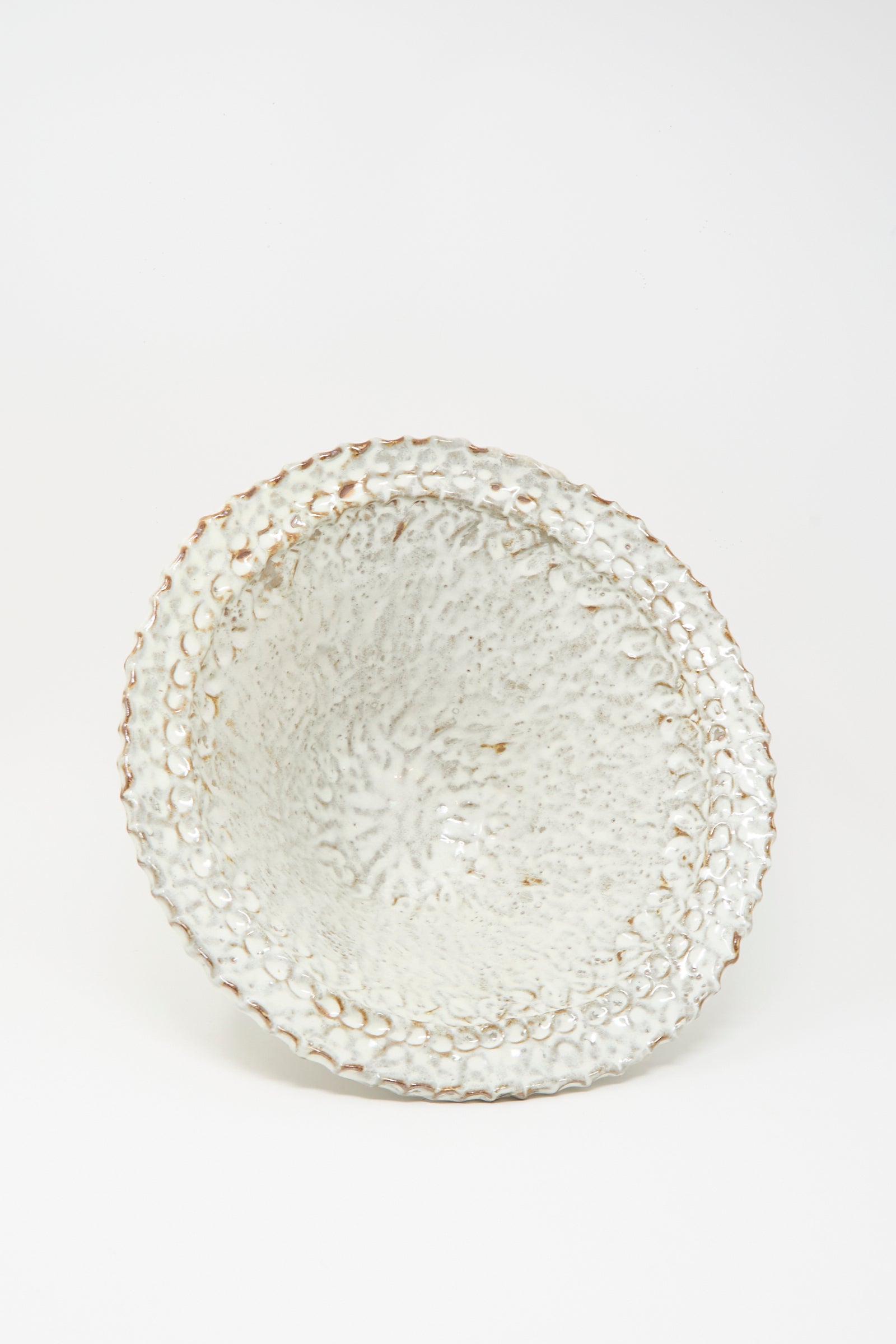 The Claire Resnick Ceramics Textured Bowl in White, featuring a handmade design with a white glaze and brown edges, is displayed against a plain white background; this large bowl brings artisanal charm to any table setting.