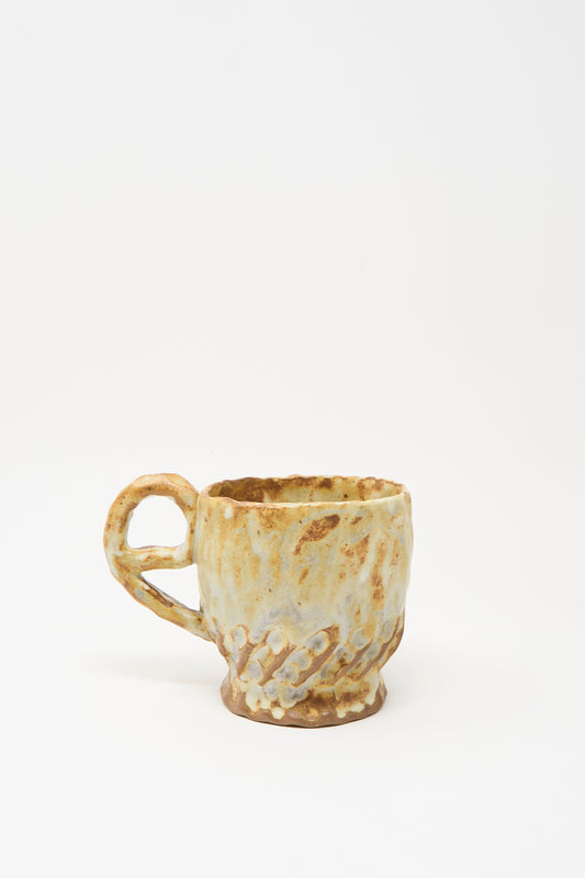 The Textured Mug in Rust Mix III by Claire Resnick Ceramics is a hand-built ceramic mug with a textured brown and beige glaze, featuring a handle and unique raised hand-shaped details that wrap around the cup. Expertly crafted and made in the USA.