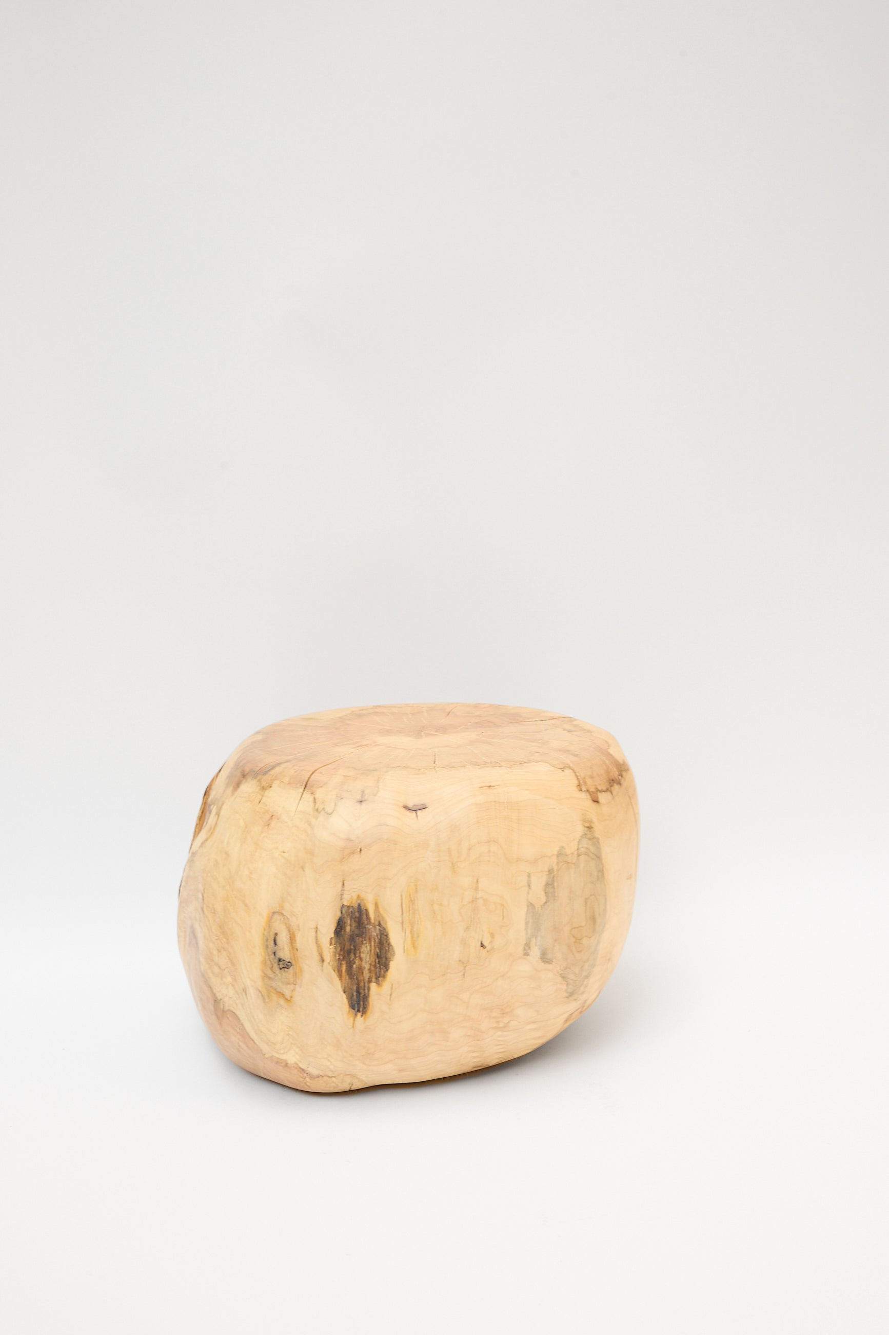 A roughly oval piece of unpolished wood, handmade in Brooklyn from a natural maple tree, the Fort Greene Maple Pouf by Cody Brgant sits against a plain white background.