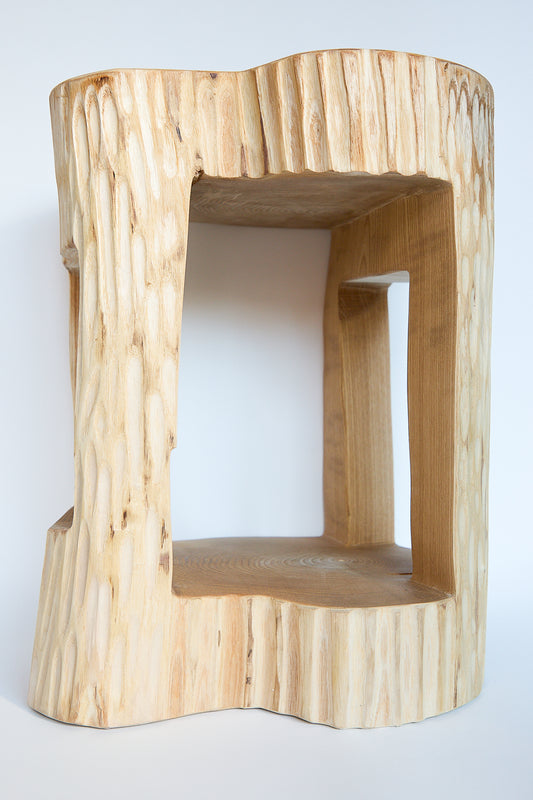 A Cody Brgant Kingston Ash Side Table I, handcrafted from a piece of wood that has been carved into a shape.