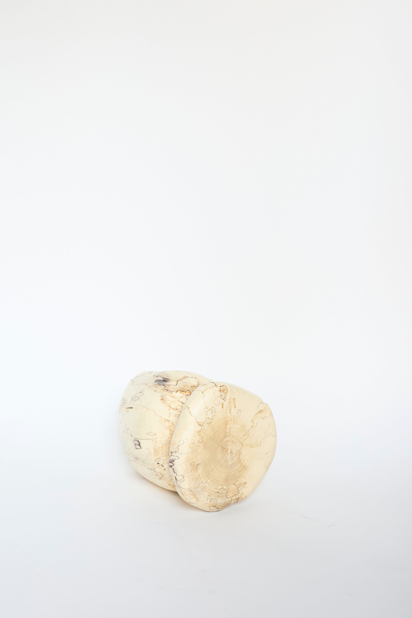 The Kingston Spalted Maple Vase by Cody Brgant, with its cylindrical form and visible grain and texture, rests on its side against a plain white background.