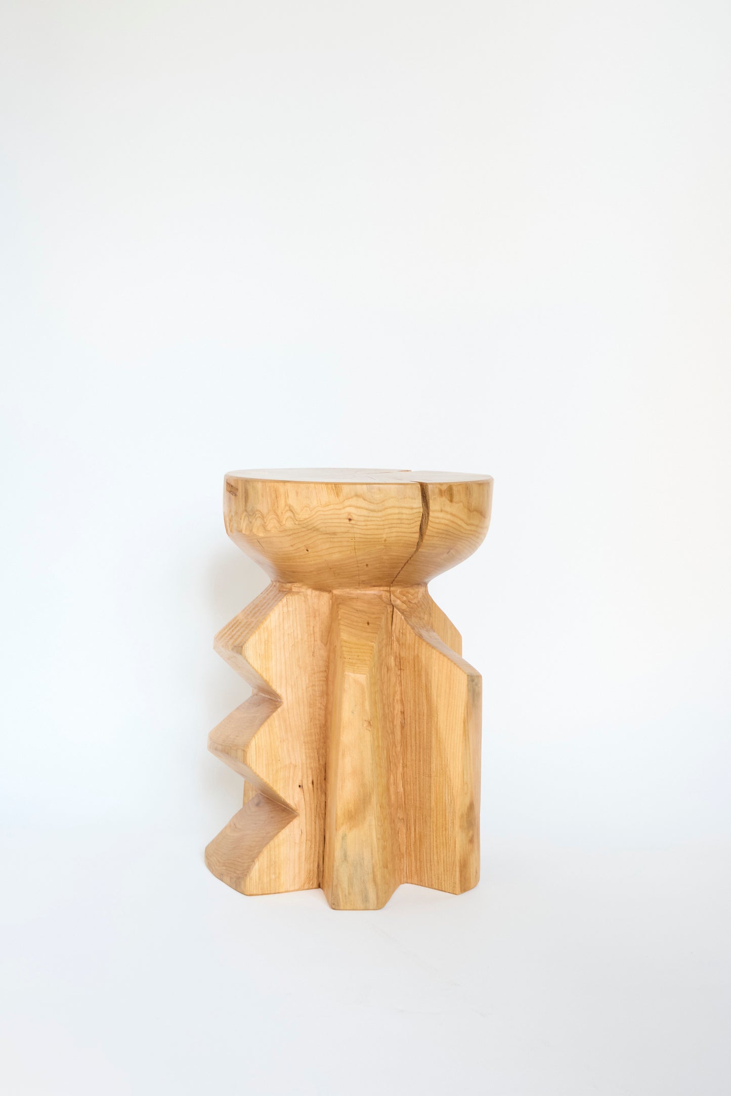 Introducing the Cody Brgant Starburst Side Table in Hogback Cherry: a finely crafted wooden table featuring a carved zigzag pattern and a natural finish. This piece stands against a plain white background.