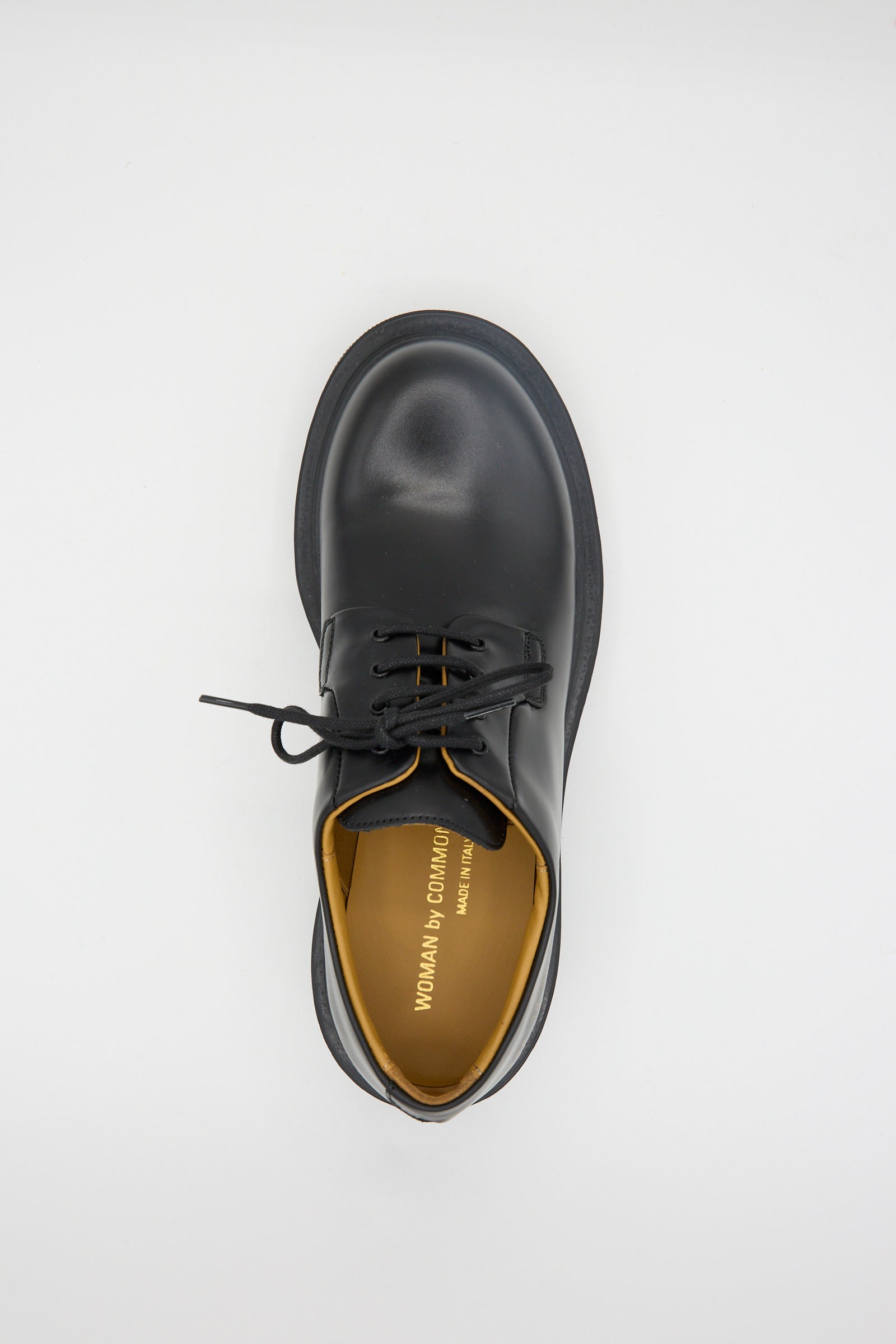 A single Common Projects Chunky Derby 6196 in black leather, with a sturdy rubber sole and tan interior, shown from above on a plain white background.