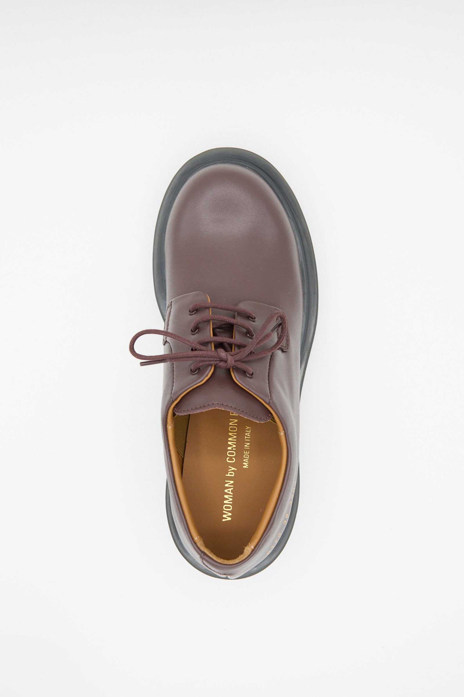 A top view of a single Chunky Derby Article 6179 in Burgundy with Gum shoe by Common Projects, featuring laces and the text "Woman by Common Projects" on the insole, crafted in Italy.