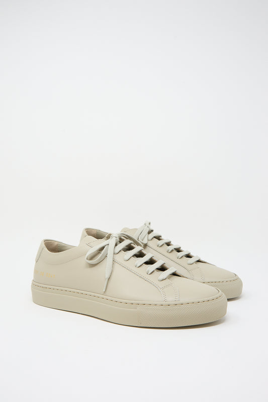 A pair of Taupe Original Achilles Low 3701 sneakers from Common Projects against a white background.