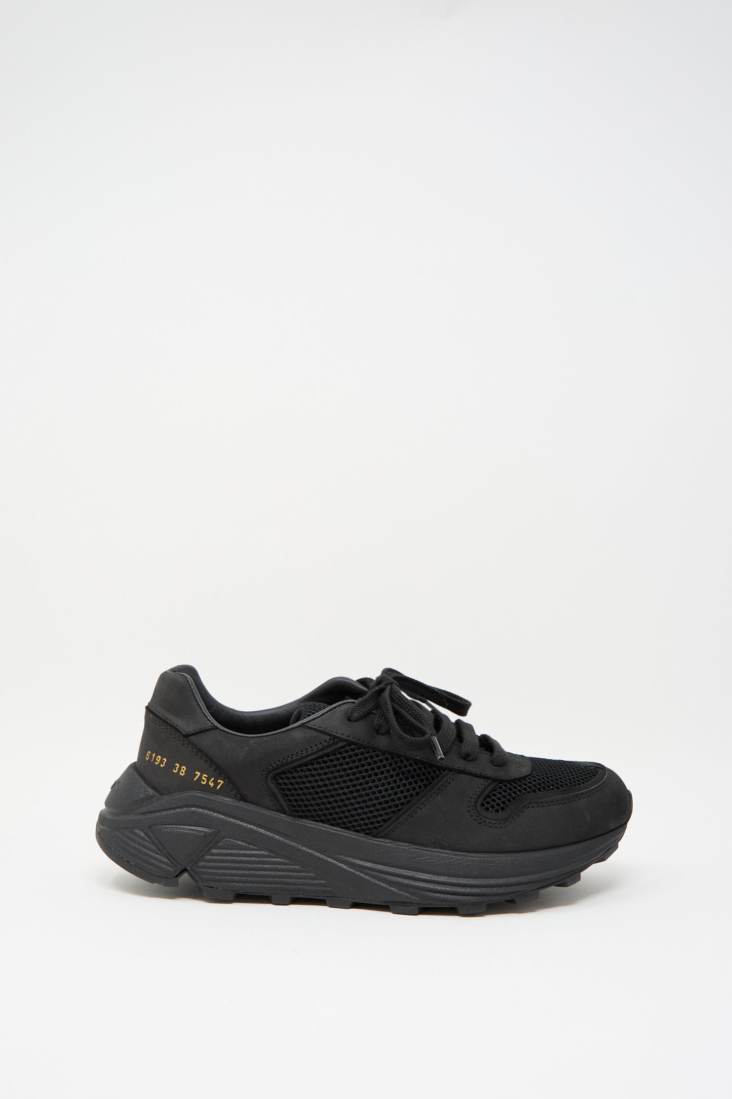 The Common Projects Premium Mesh Runner in Black is an elegant Italian-made retro sneaker with lace-up design, textured sole, mesh sides, and a small gold number near the heel.