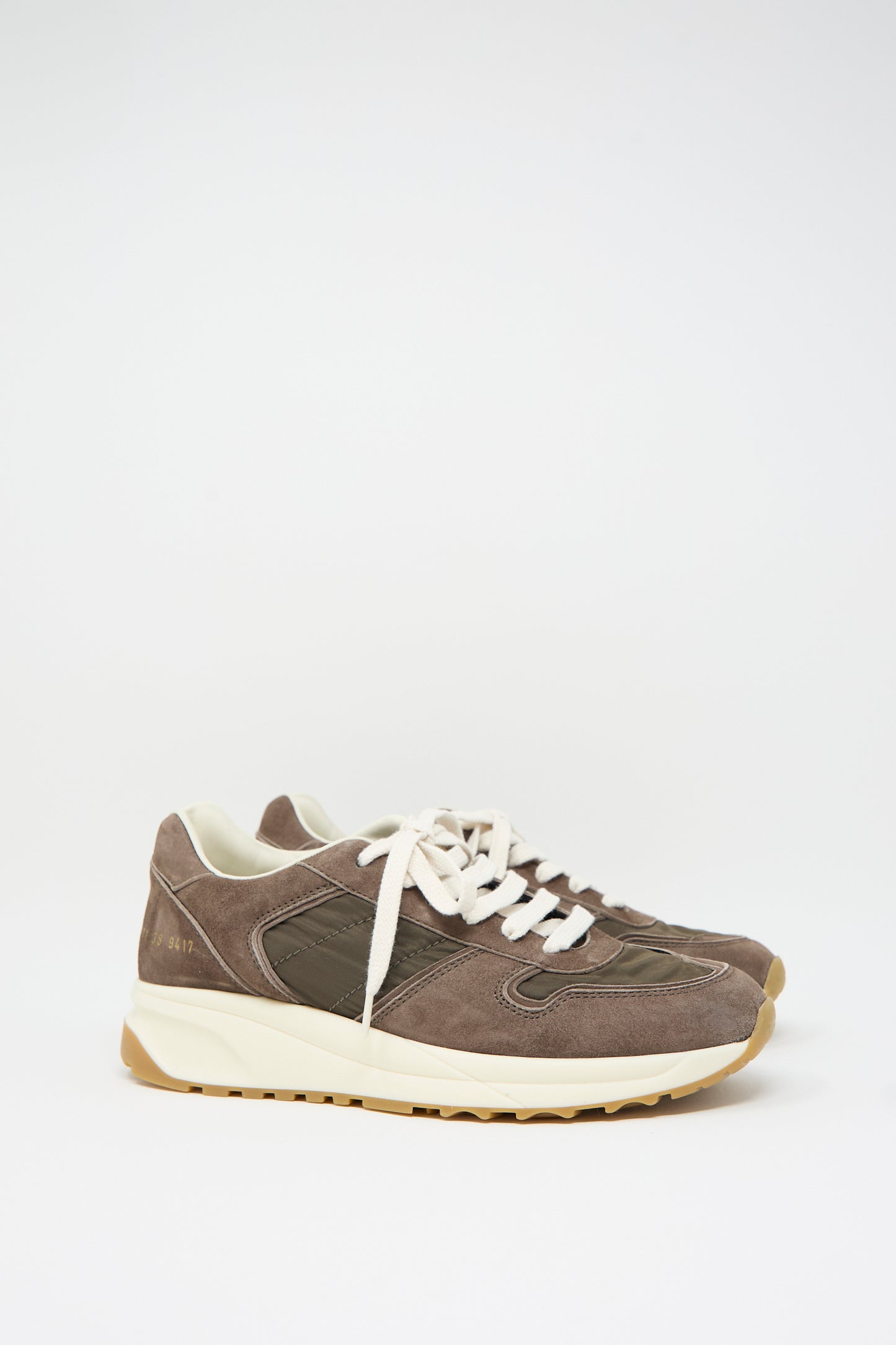 A pair of Track Premium Article 6171 sneakers in Coffee by Common Projects, crafted from brown suede and nylon, featuring white laces and beige soles with a cushioned footbed, displayed side by side against a plain white background.