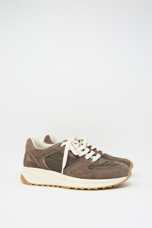 A pair of Track Premium Article 6171 sneakers in Coffee by Common Projects, crafted from brown suede and nylon, featuring white laces and beige soles with a cushioned footbed, displayed side by side against a plain white background.