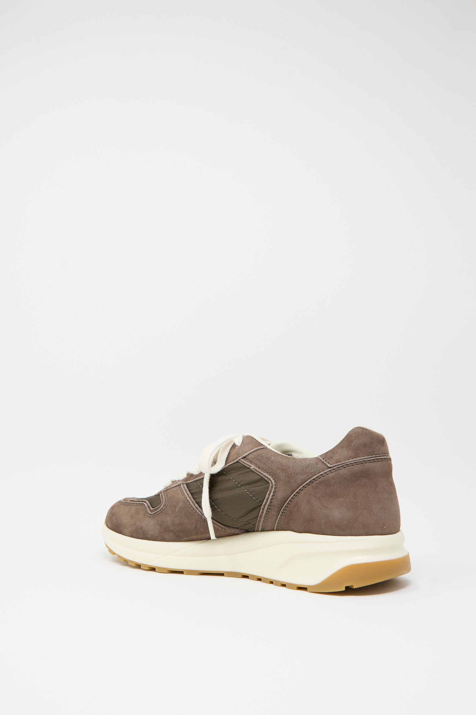 A single Track Premium Article 6171 in Coffee by Common Projects, featuring a brown and beige color scheme, white laces, a yellow-tinted sole, and a cushioned footbed, viewed from the side on a plain white background.