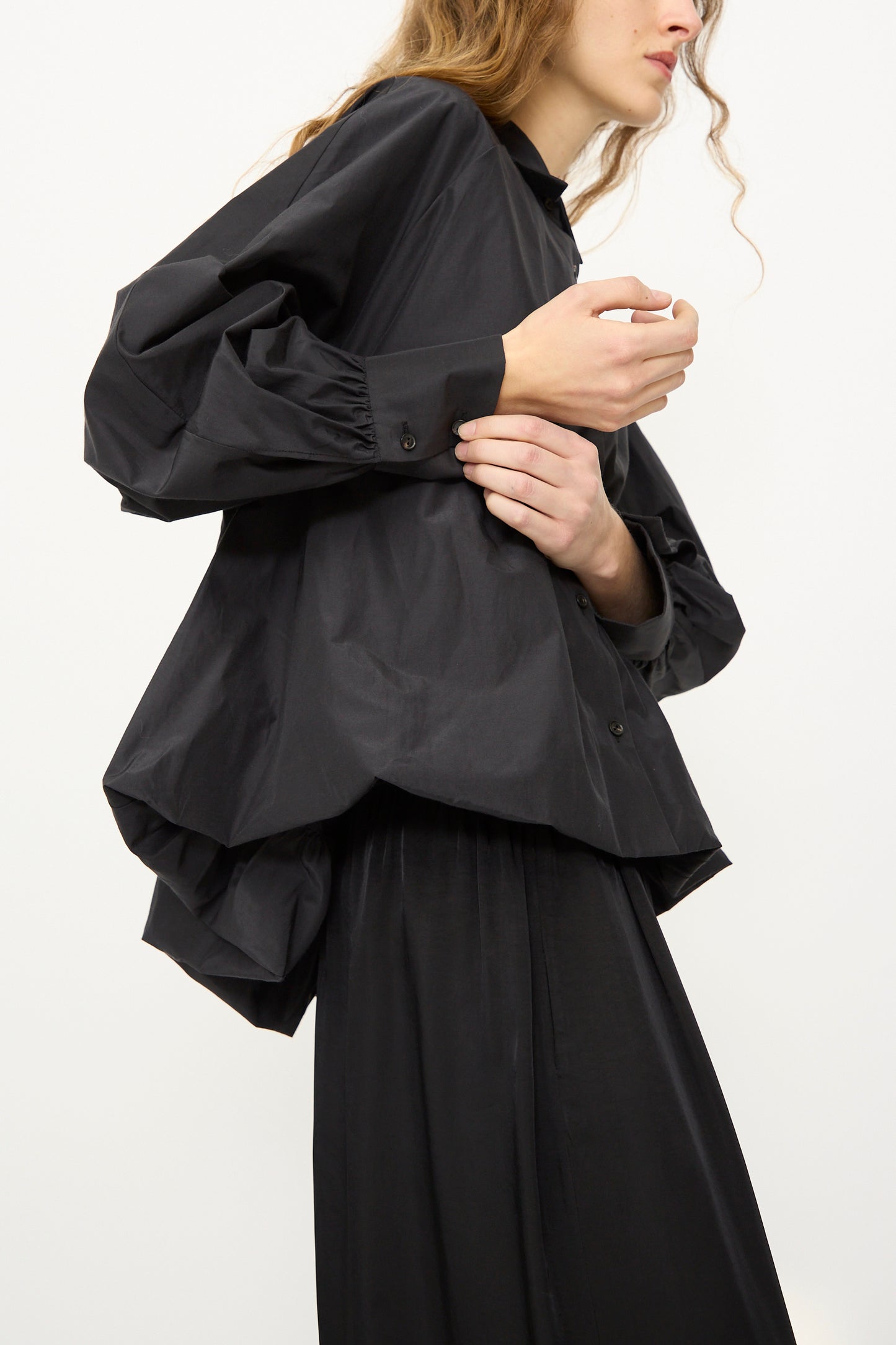 A model wears the Cordera Balloon Shirt in Black, featuring voluminous sleeves, paired with a matching black skirt against a plain white background.
