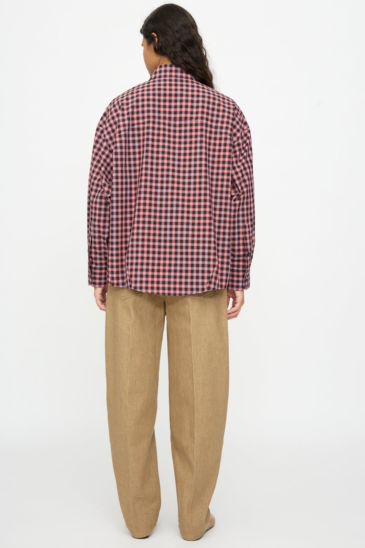 Back view of a person wearing a Cordera Checked Oversized Shirt in Orange and Black with an Italian collar and tan trousers.