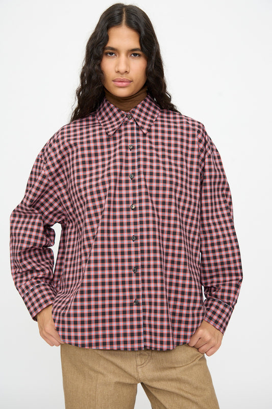 Person wearing a Cordera Checked Oversized Shirt in Orange and Black, featuring an oversized, long-sleeved silhouette with an Italian collar.