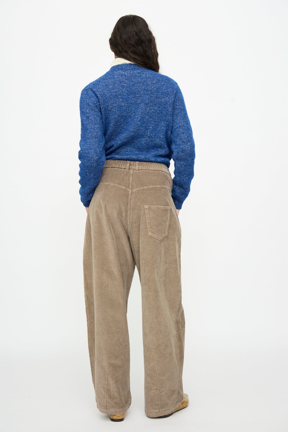 Back view of a person wearing Cordera Corduroy Baggy Pants in Sage and a blue sweater.