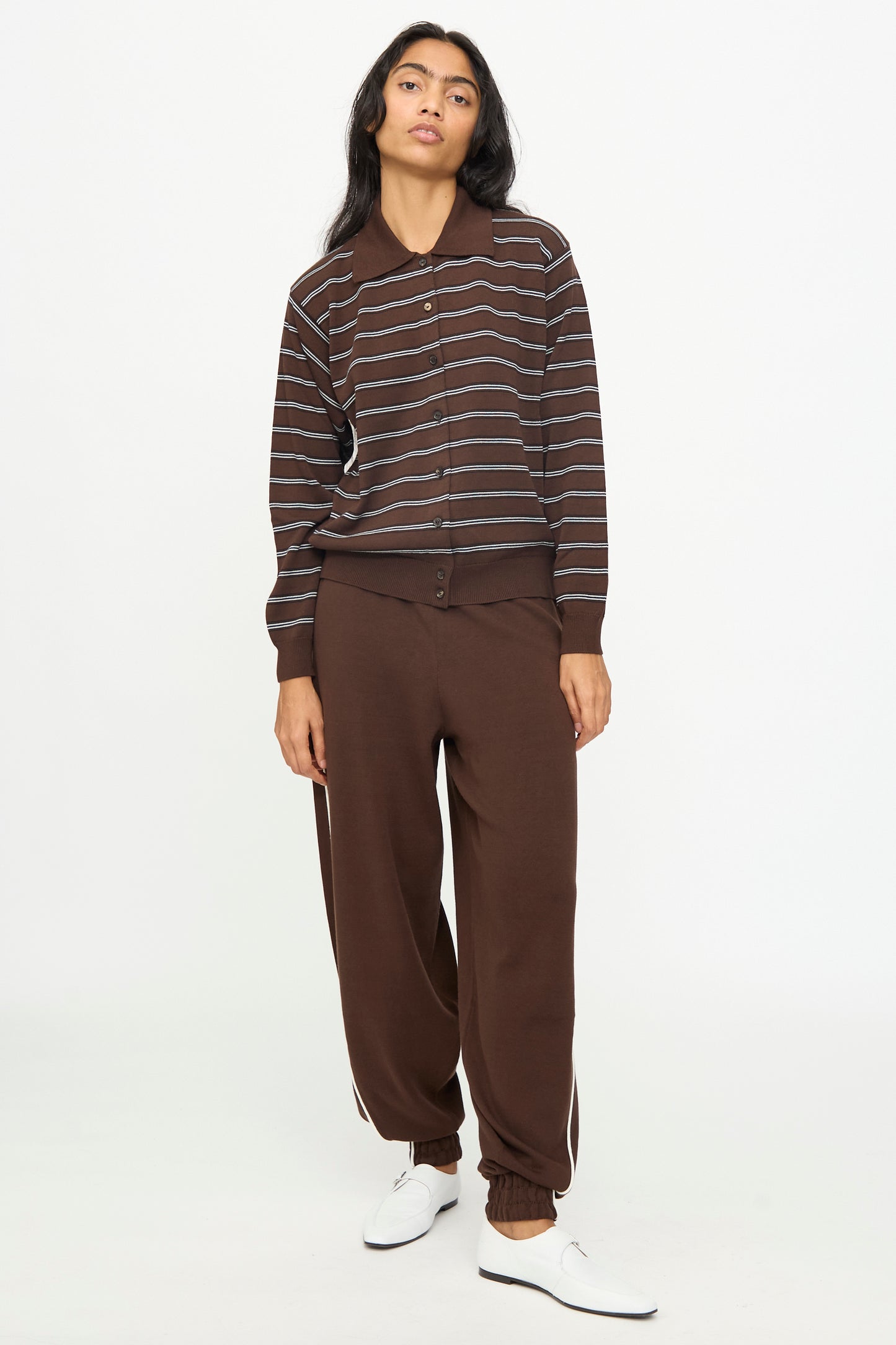 A person is wearing the Cordera Cotton Polo Cardigan in Striped along with matching brown pants and white shoes, standing against a plain white background.