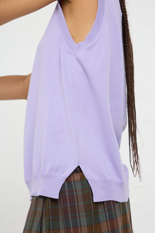 A person wearing a light purple, Cordera Organic Cotton Tank Top in Cardo under a plaid dress, with a focus on the clothing rather than the individual.