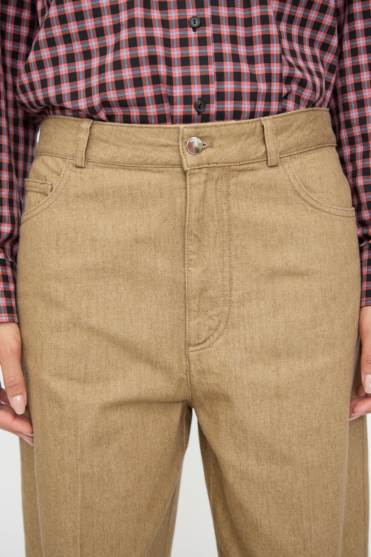 Cordera Denim Carrot Pants in Beige featuring a high-waisted fit and button fly, worn with a red and black plaid button-down shirt.