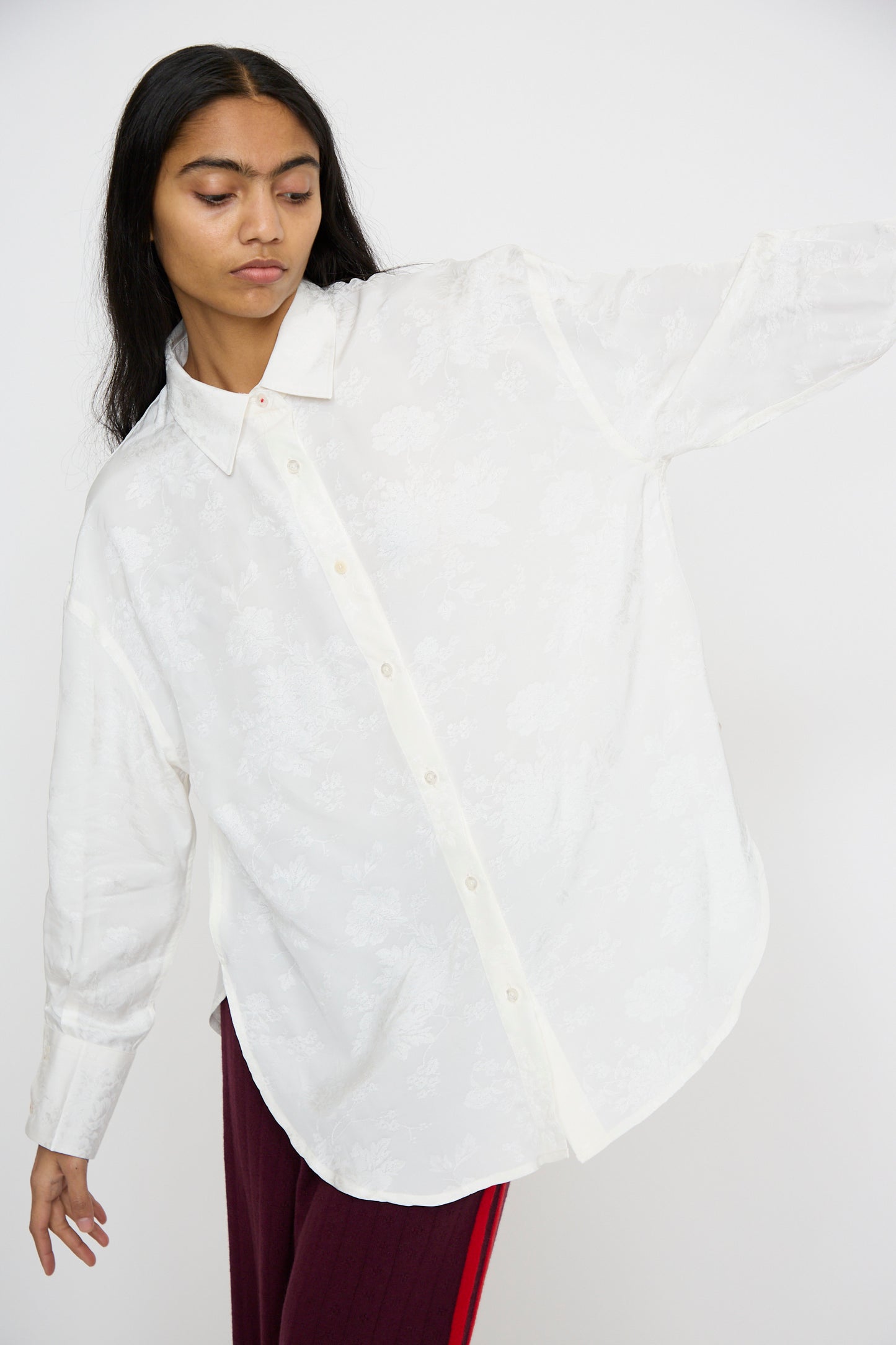 A person wearing the Cordera Flower Jacquard Shirt in white and red pants stands against a plain background.