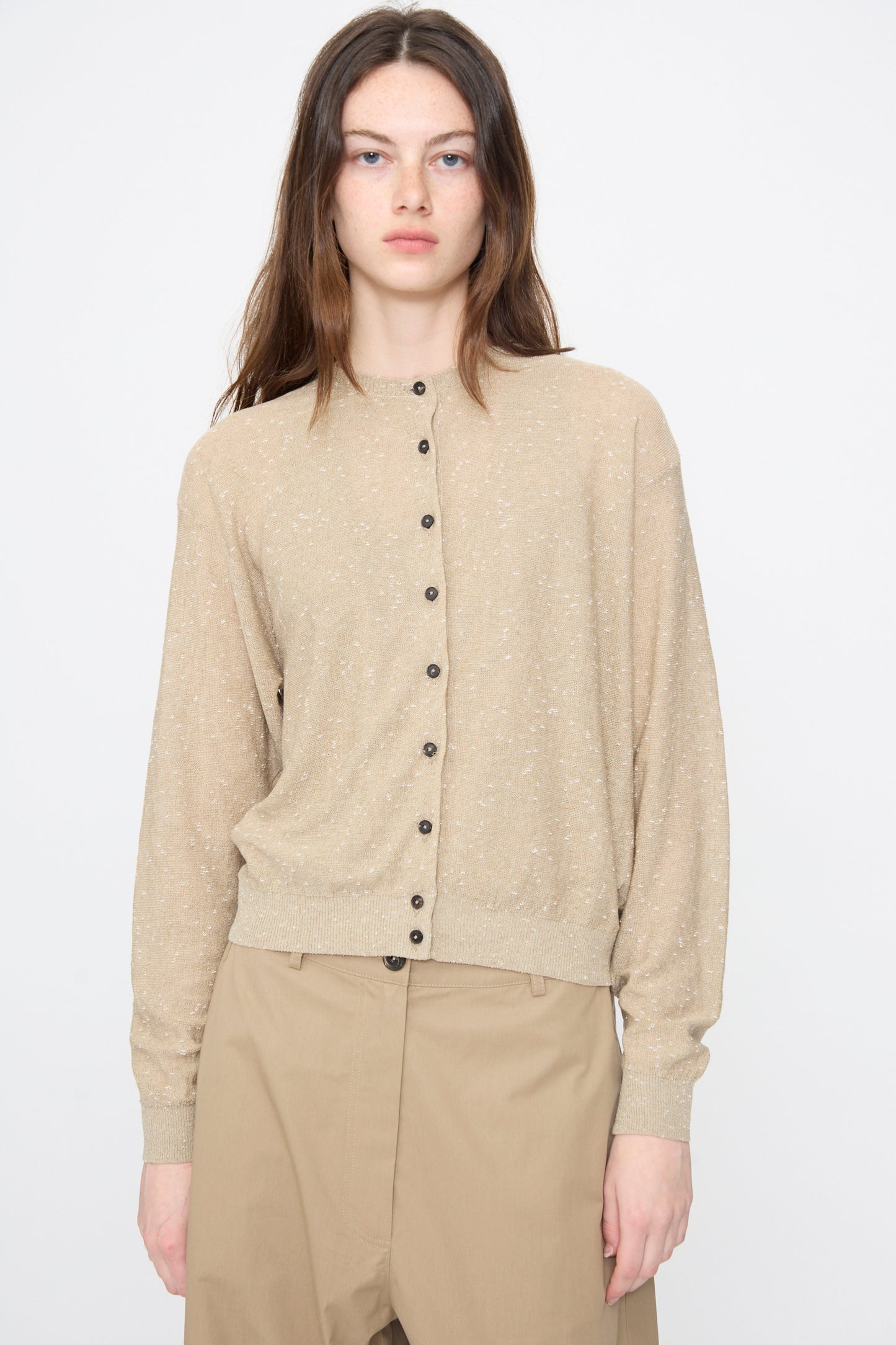 A person wears the Cordera Linen and Cotton Flecked Cardigan in Taupe with matching high-waisted trousers, standing against a plain white background.
