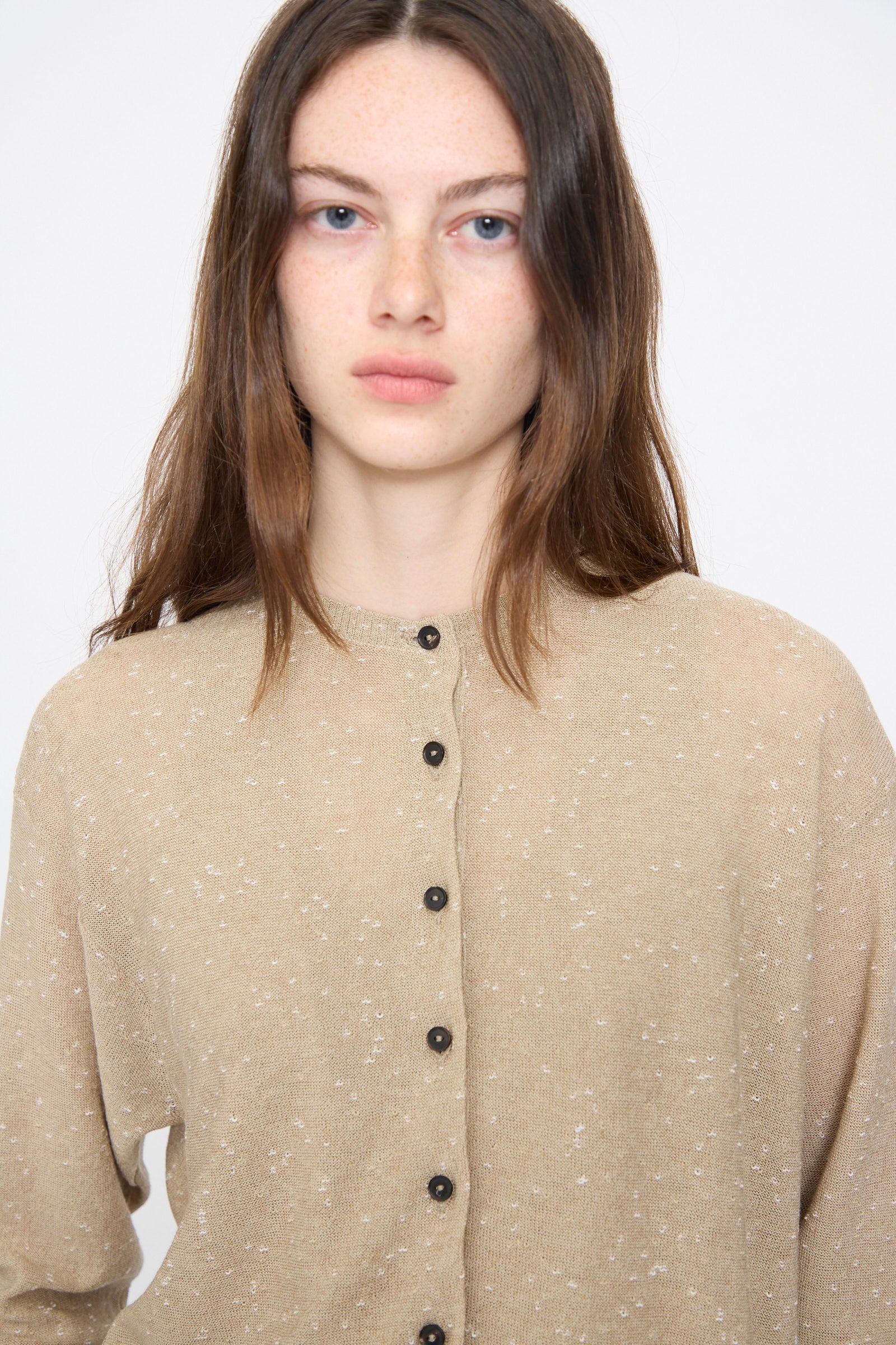 A person with long brown hair wears the Cordera Linen and Cotton Flecked Cardigan in Taupe, looking directly at the camera against a plain background.