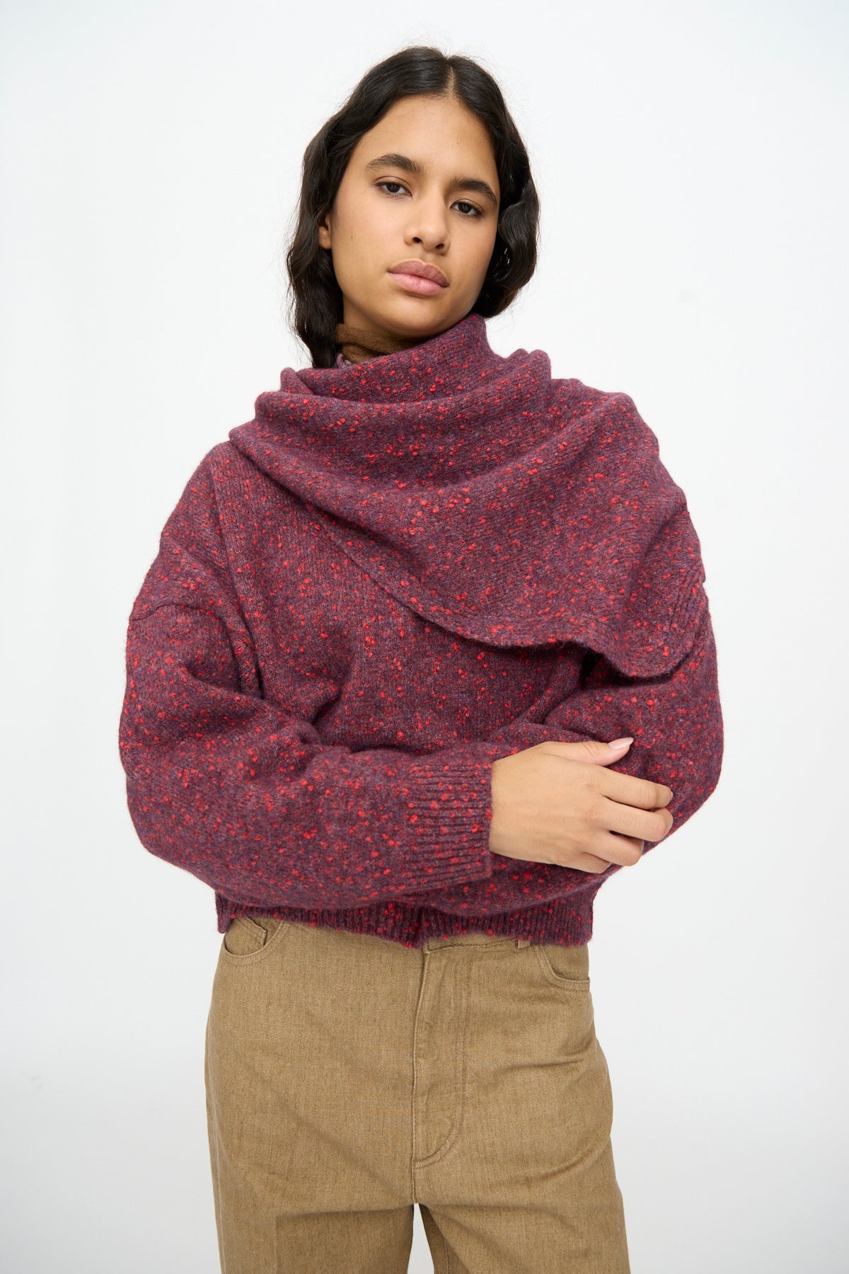 A person wearing a triangular, speckled-finish Maxi Bandana in Beaujolais draped over a matching burgundy sweater.
