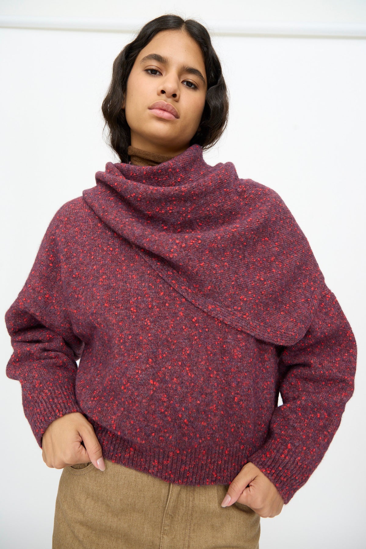 A person wearing a speckled deep red cotton blend cowl-neck sweater with a matching Cordera Maxi Bandana in Beaujolais.